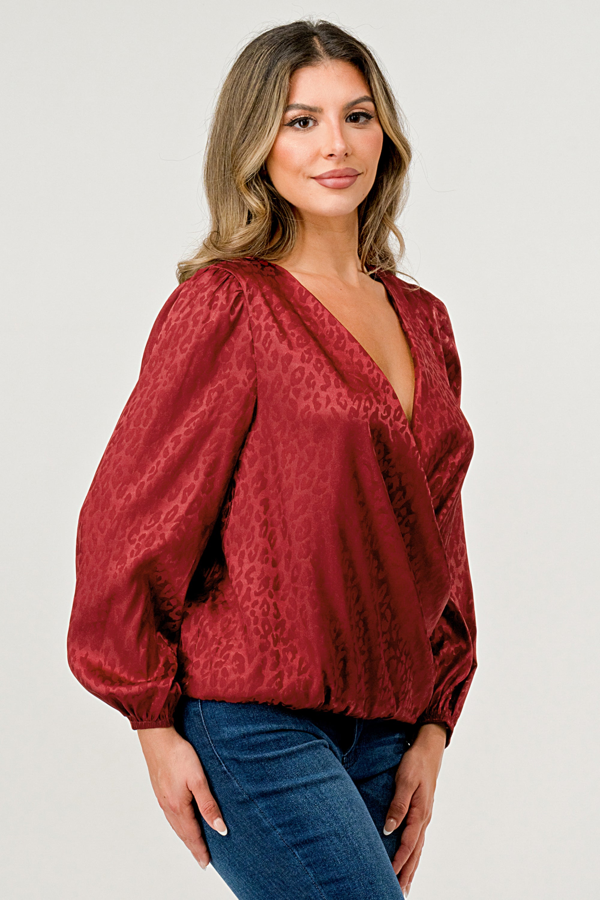 Leopard Print V-Neck Wrap Blouse with long sleeves and elastic waist, showcasing a chic satin finish and elegant jacquard pattern.