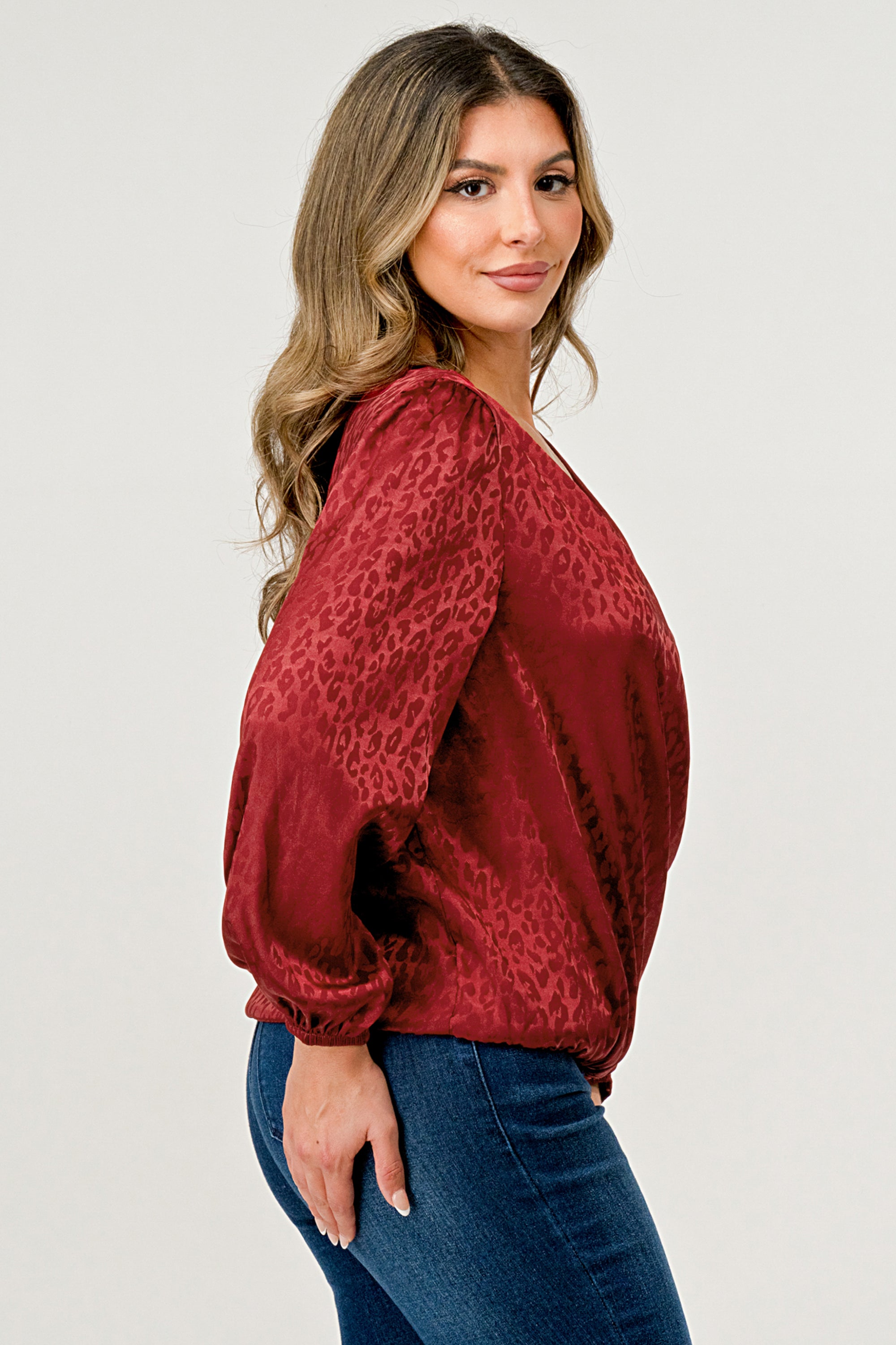 Leopard Print V-Neck Wrap Blouse with long sleeves and elastic waist, showcasing a chic satin finish and elegant jacquard pattern.