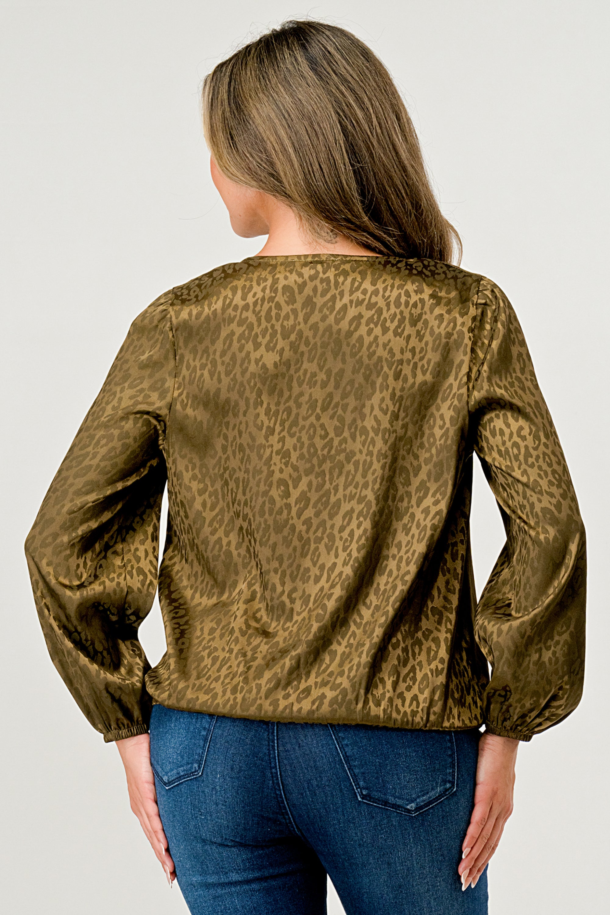 Leopard Print V-Neck Wrap Blouse with long sleeves and elastic waist, showcasing a chic satin finish and elegant jacquard pattern.