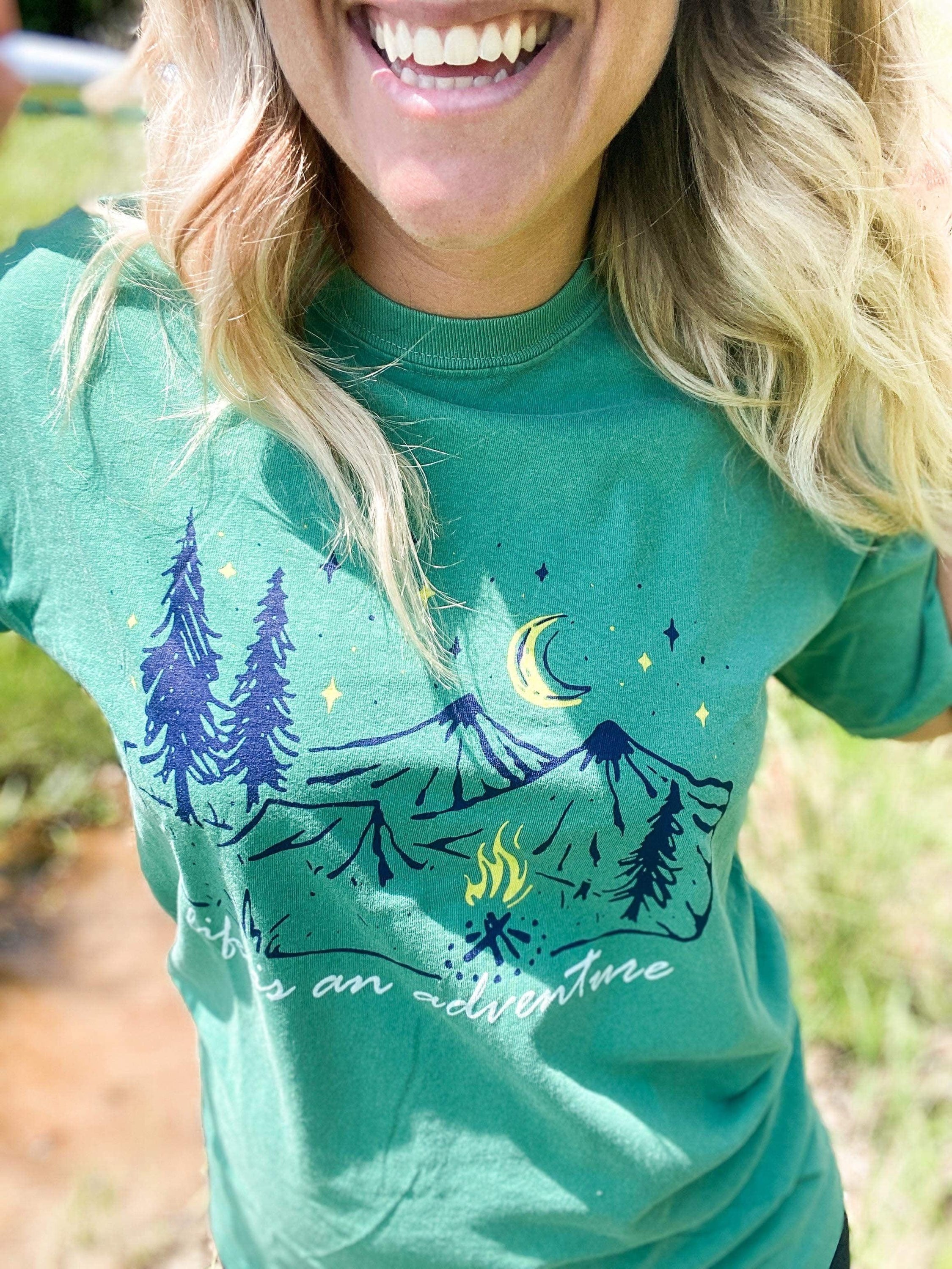 Grass Green tee featuring 'Life Is An Adventure' design with navy, lemon yellow, and pastel green screen print on soft-washed cotton fabric.