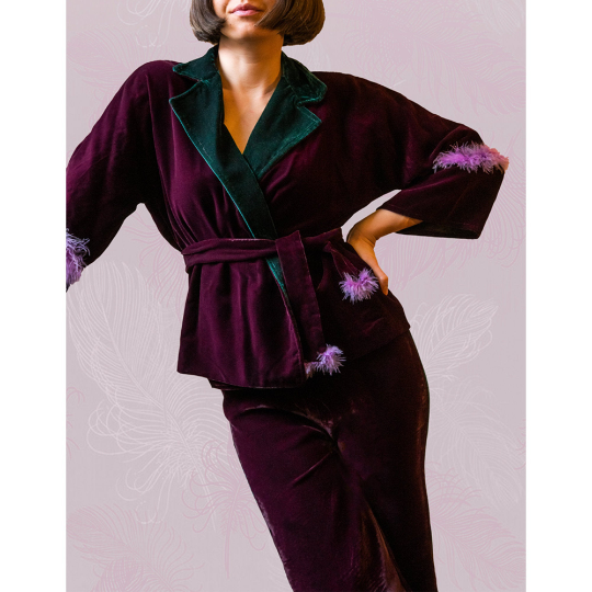 LILLÀ pajama suit featuring violet velvet fabric, green velvet collar, and lilac feather details on the arms and pants.