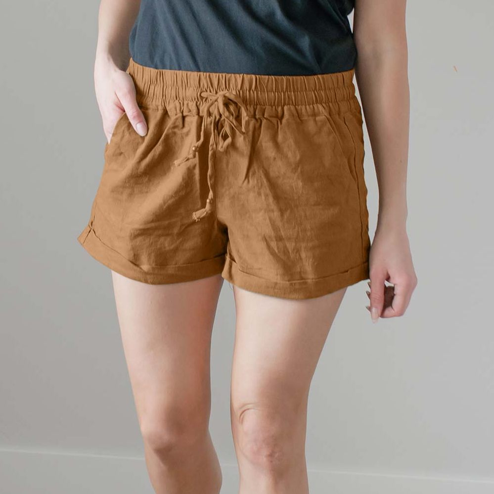 A pair of stylish linen drawstring-waist shorts with pockets, featuring cuffs at the leg openings, displayed in a vibrant color.
