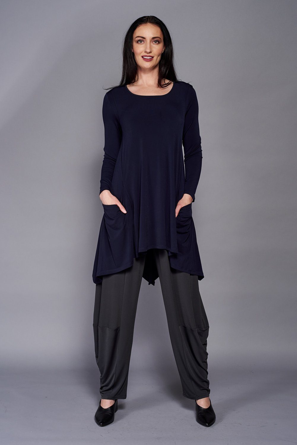 A stylish London Pocket Tunic featuring a scoop neckline, long sleeves, front pockets, and a vented slit design at the back, perfect for casual wear.