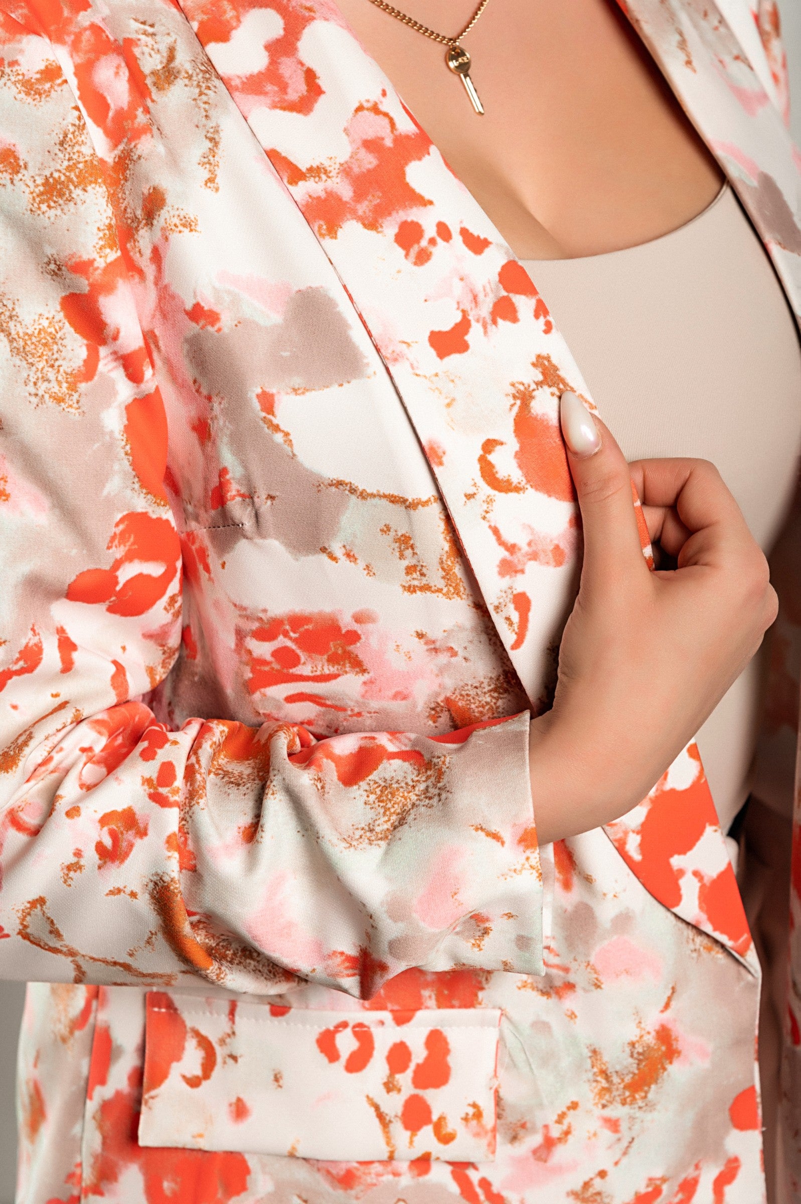 Red long blazer with classic collar, padded shoulders, and 3/4 sleeves, featuring gathered hem and faux pockets, fully lined for comfort.