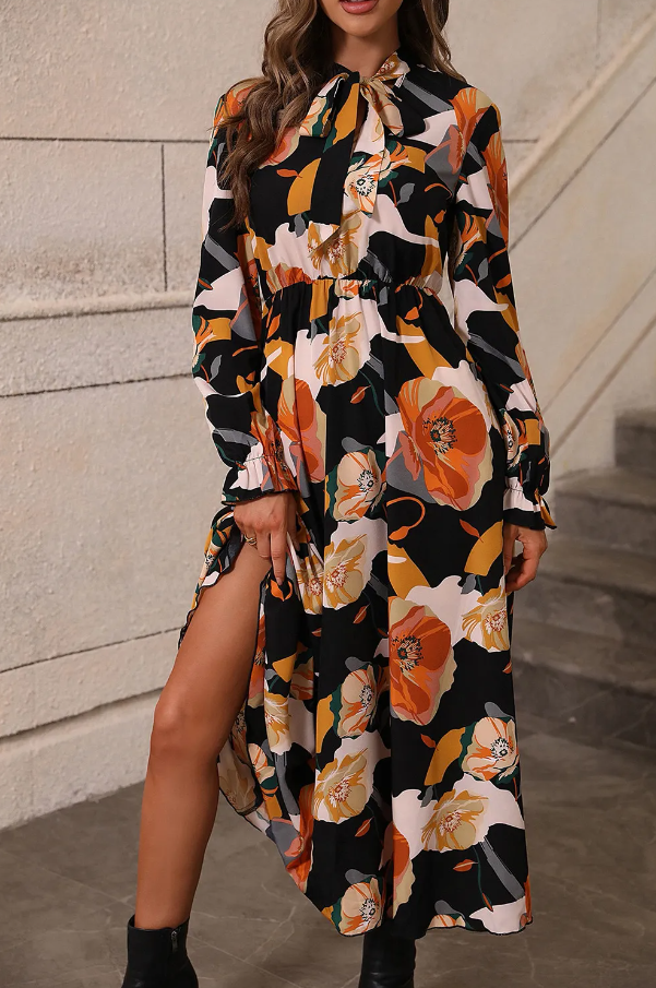 Elegant long orange dress with floral print, featuring long sleeves and a round neckline with a bow.