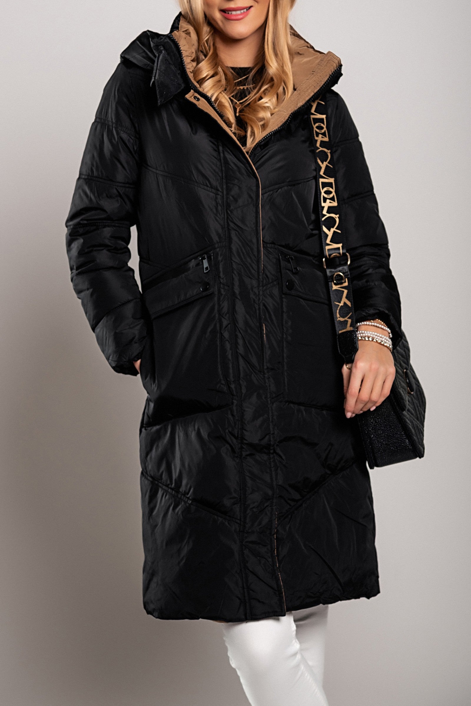 Long padded black jacket with high neck and zipped pockets, knee-length design.