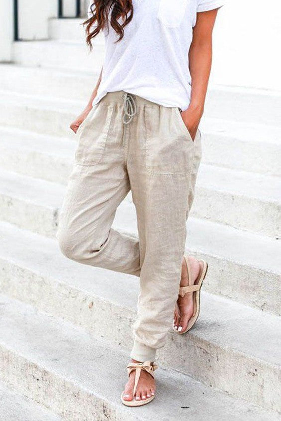 Beige long trousers with pockets and elastic waist, made from cotton and linen blend, featuring a drawstring and ankle compression.