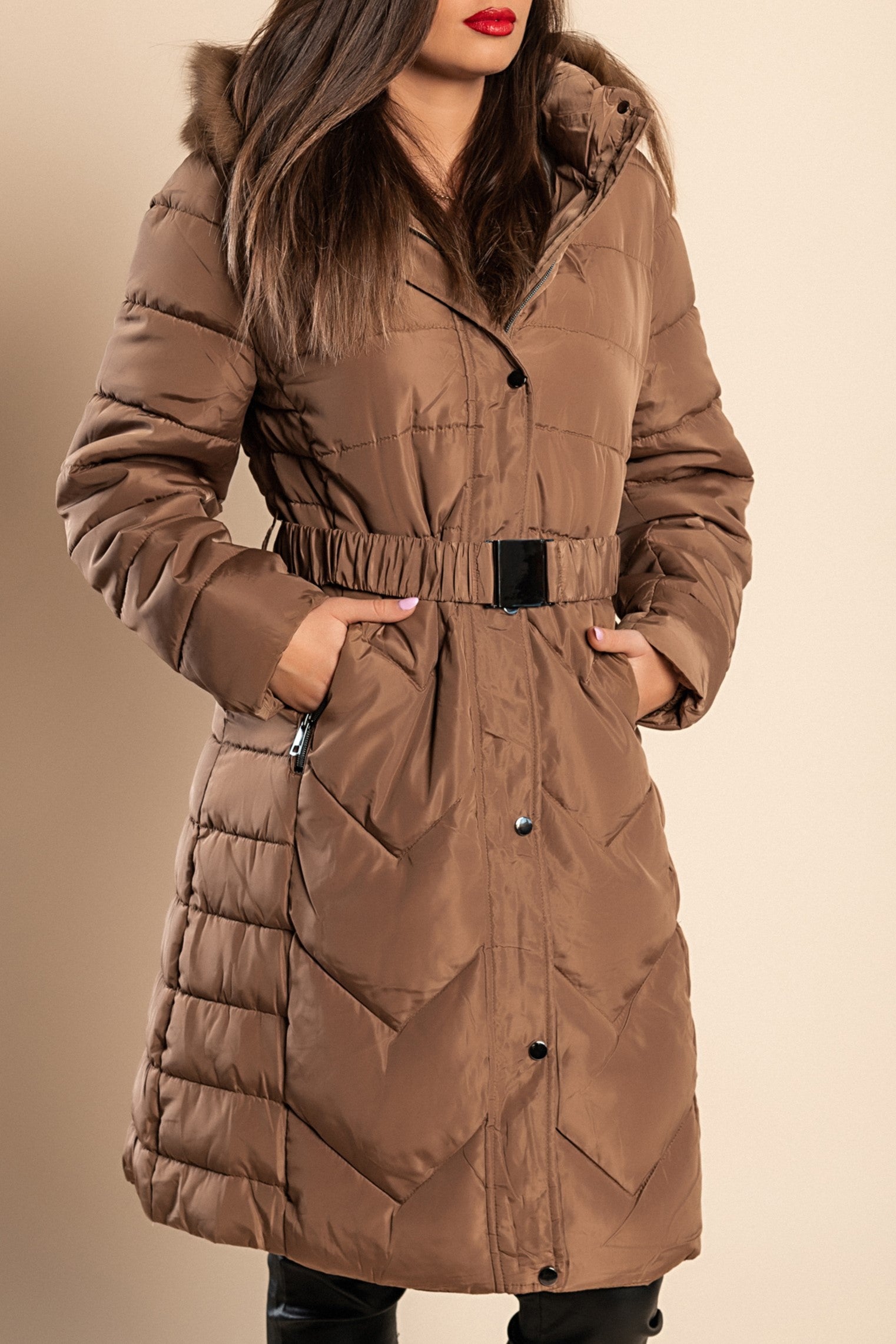 Longer padded winter jacket in camel color with hood and synthetic fur, designed for plus sizes, featuring zip closure and side pockets.