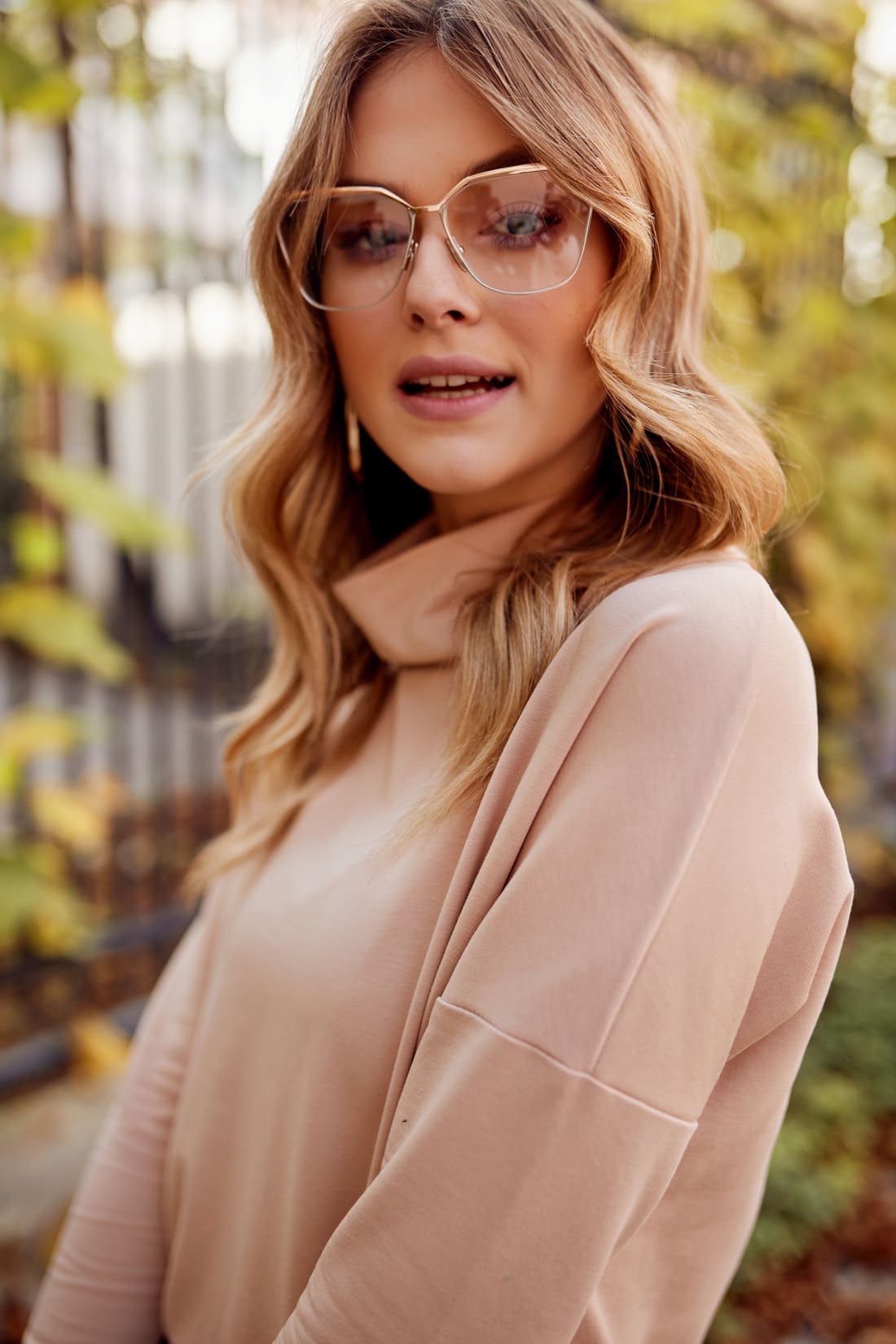 Beige loose dress with turtleneck and side pockets, showcasing a relaxed fit and stylish design.