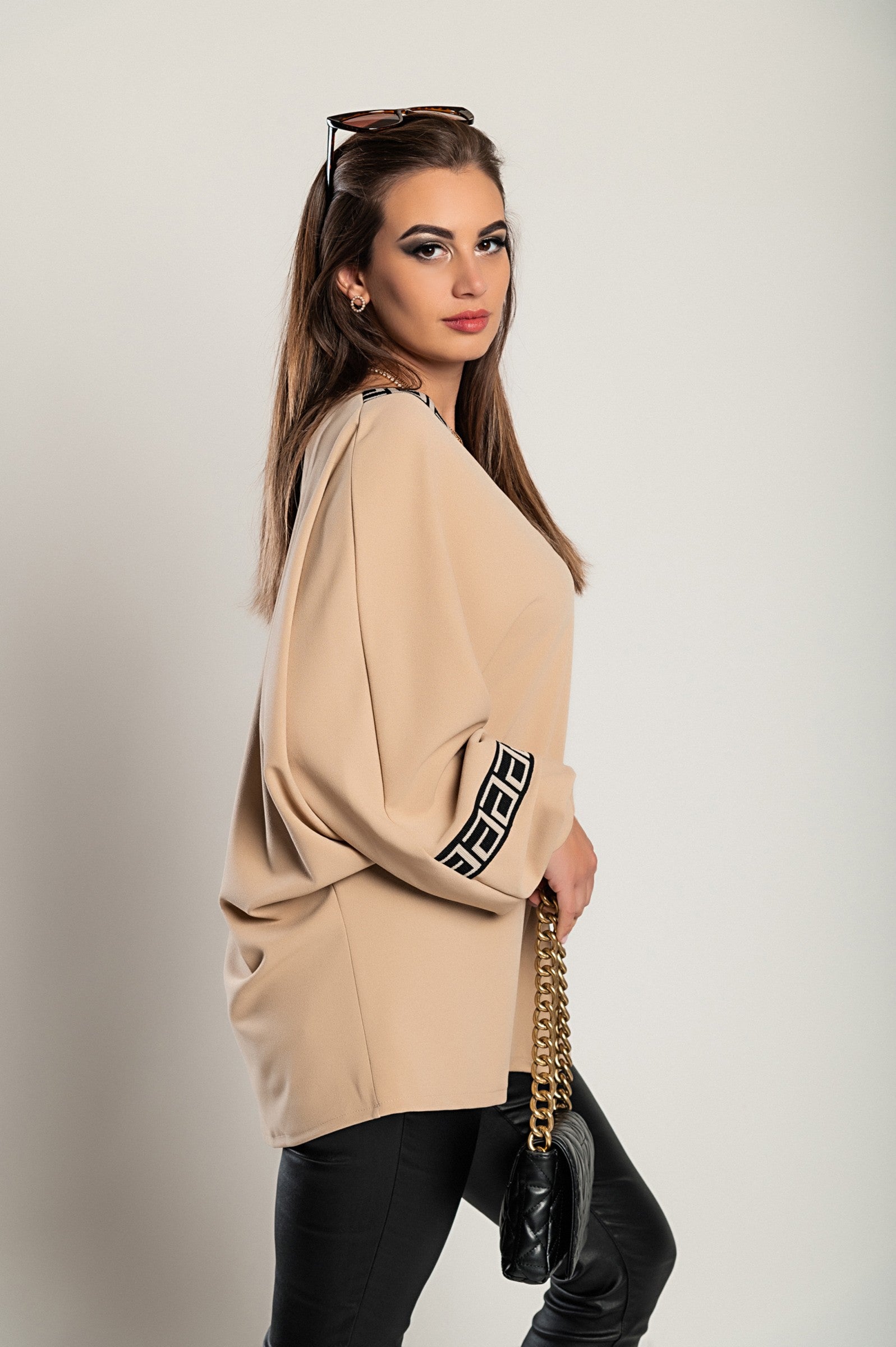 Loose beige top with geometric print featuring a deep V-neckline and long sleeves, designed for comfort and style.