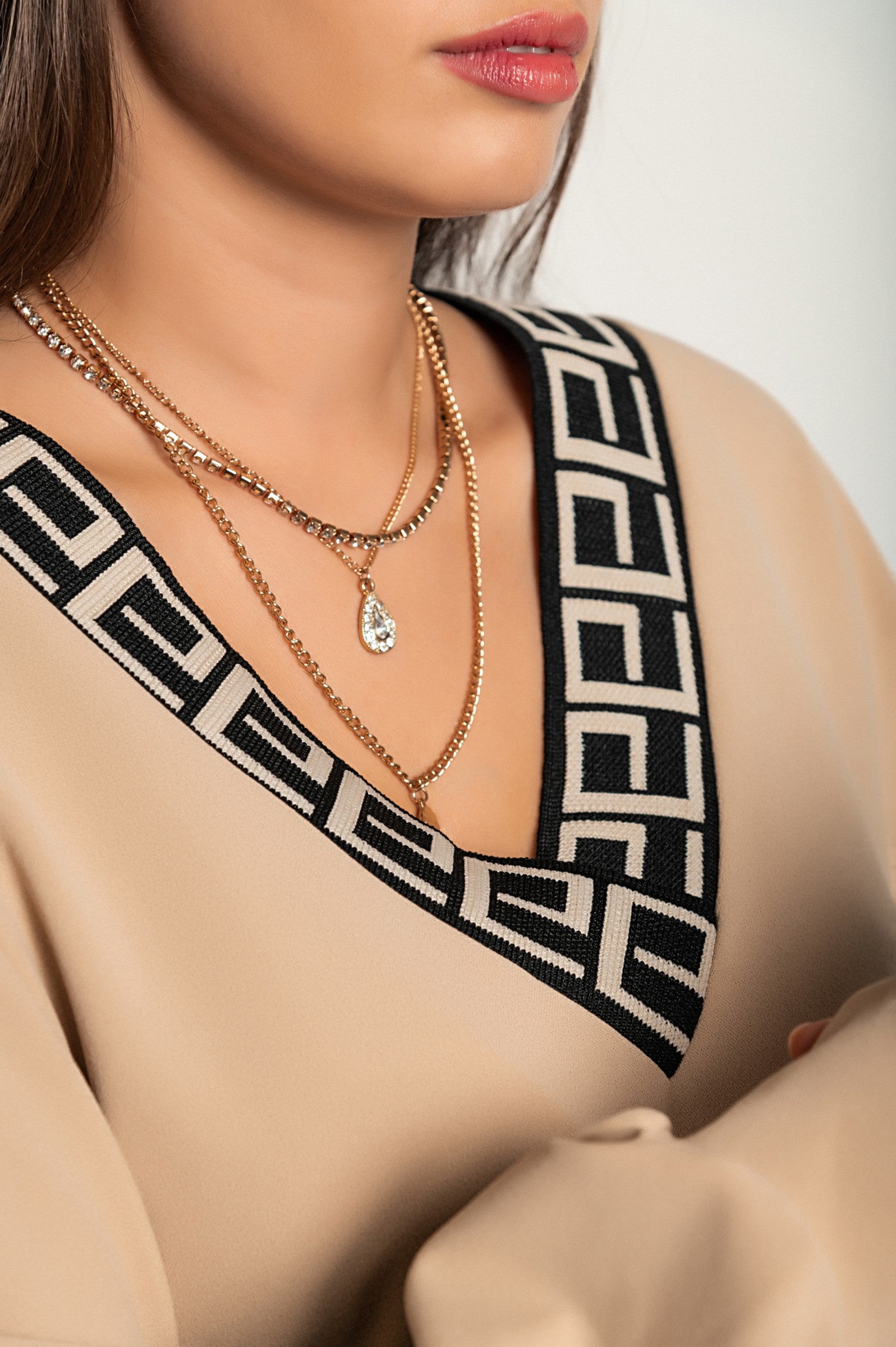 Loose beige top with geometric print featuring a deep V-neckline and long sleeves, designed for comfort and style.