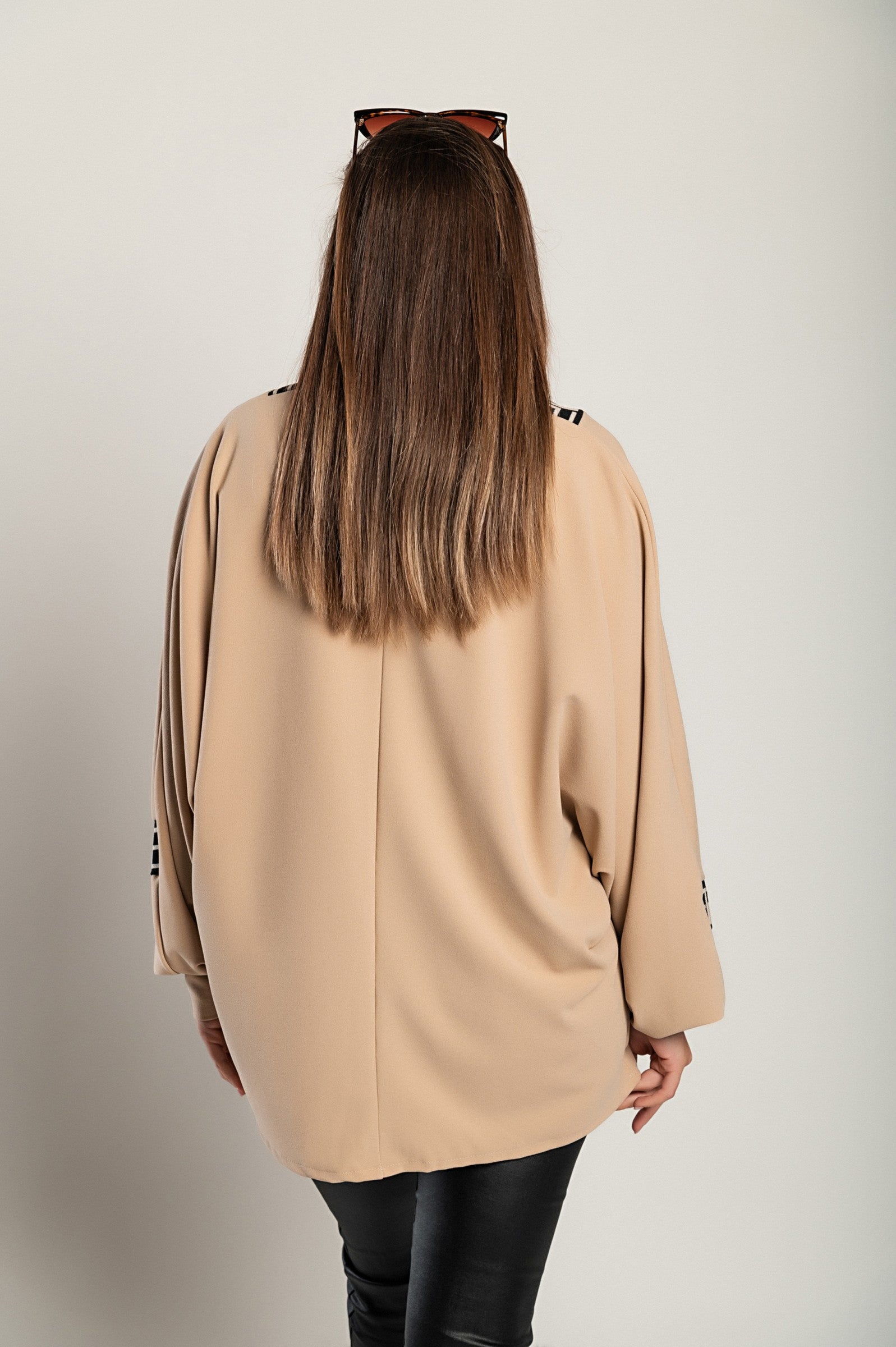 Loose beige top with geometric print featuring a deep V-neckline and long sleeves, designed for comfort and style.