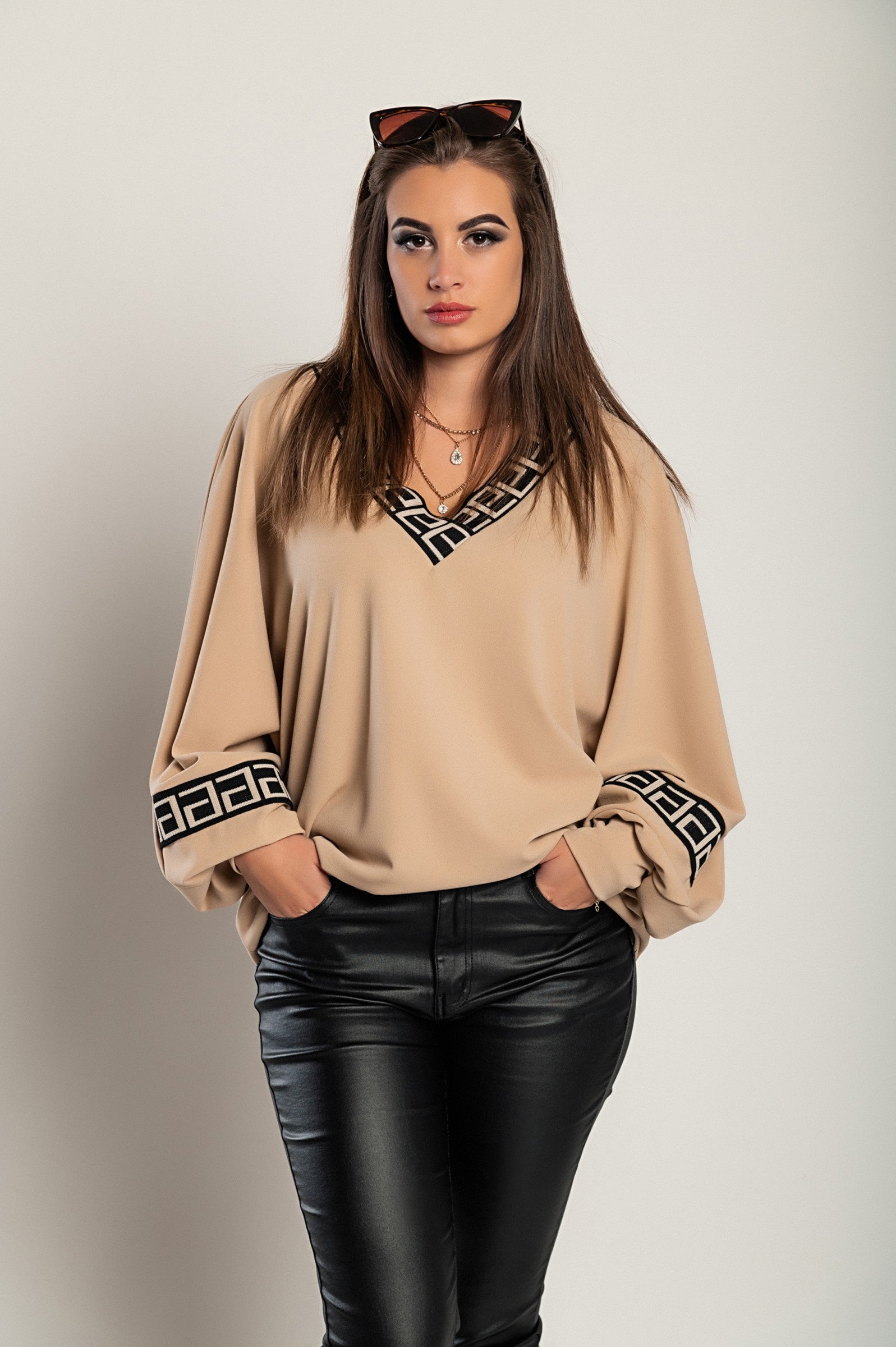 Loose beige top with geometric print featuring a deep V-neckline and long sleeves, designed for comfort and style.