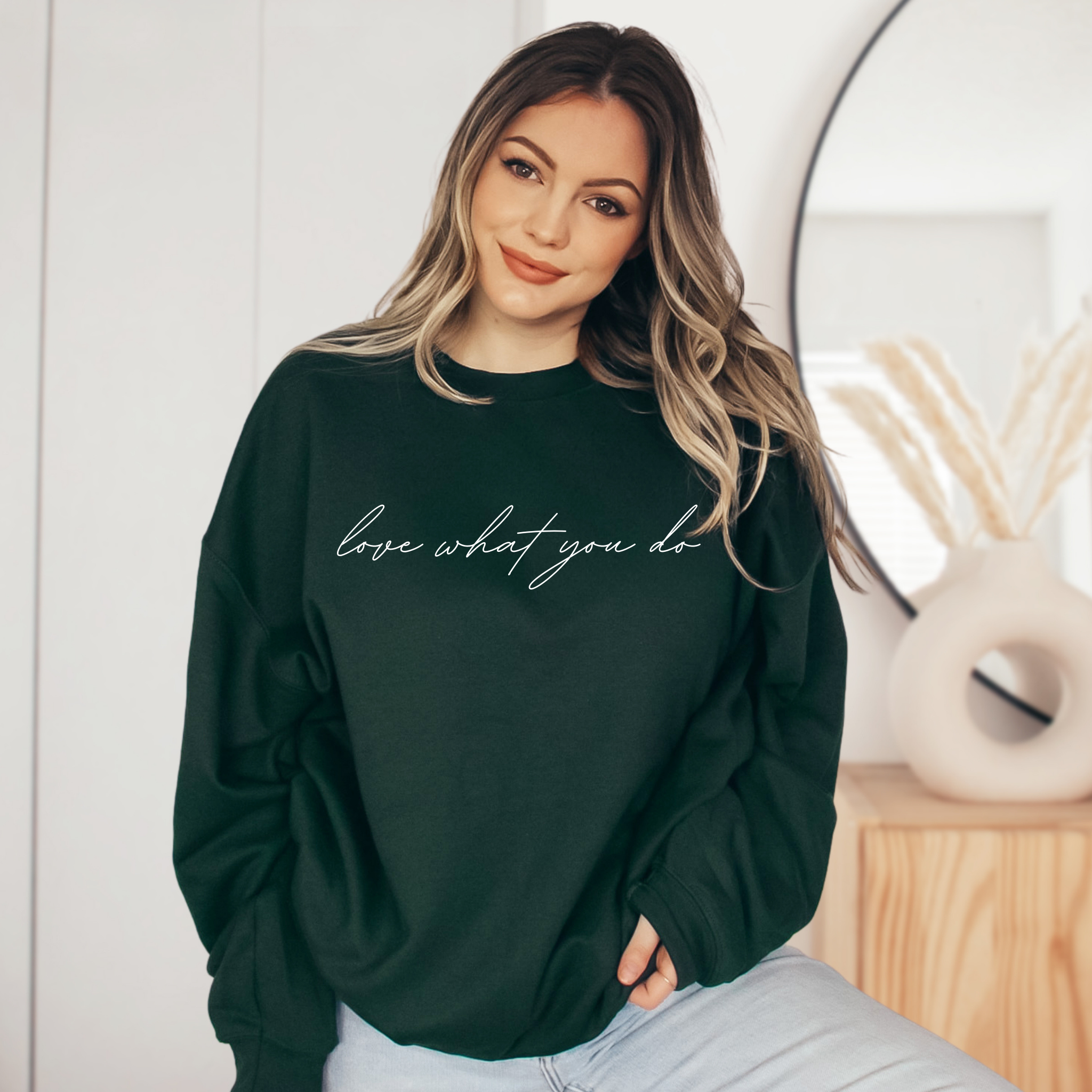 A stylish unisex sweatshirt featuring the motivational phrase 'Love What You Do' in bold lettering, perfect for casual wear.
