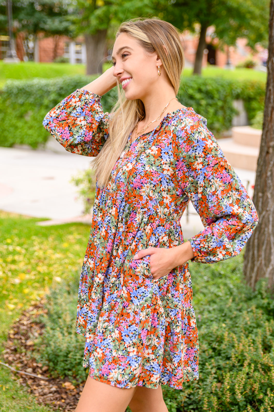 Loving Life Tiered Knee Length Floral Dress featuring a vibrant floral print on a solid black background, with a ruffle neckline and puff sleeves.