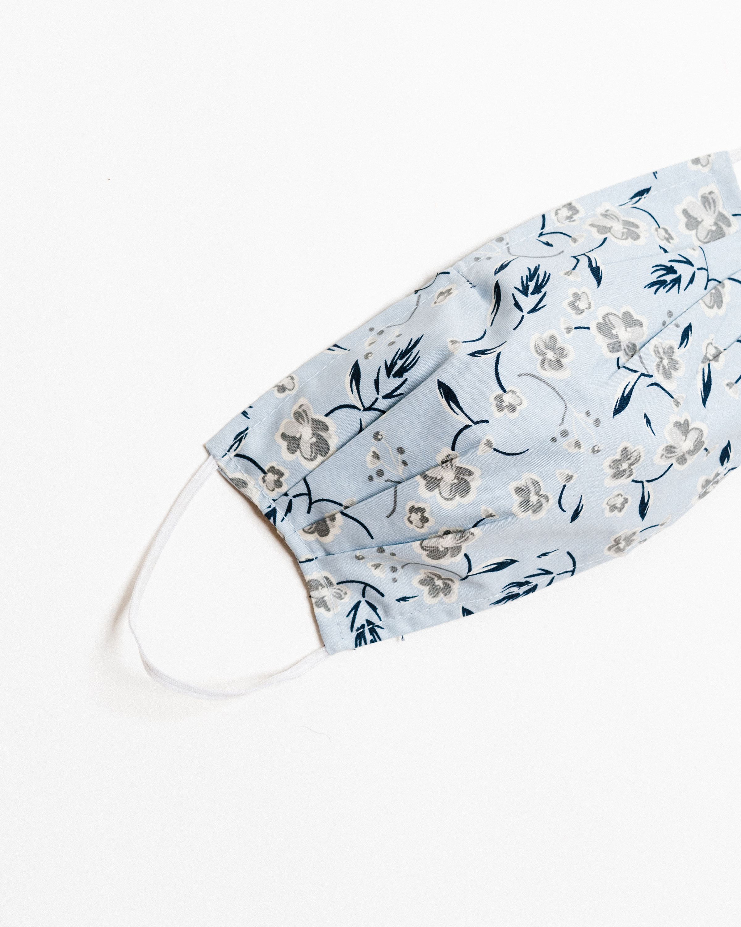 Lucy Blue Face Mask made from 100% cotton, featuring a breathable double-layer design and elastic ear straps for comfort.