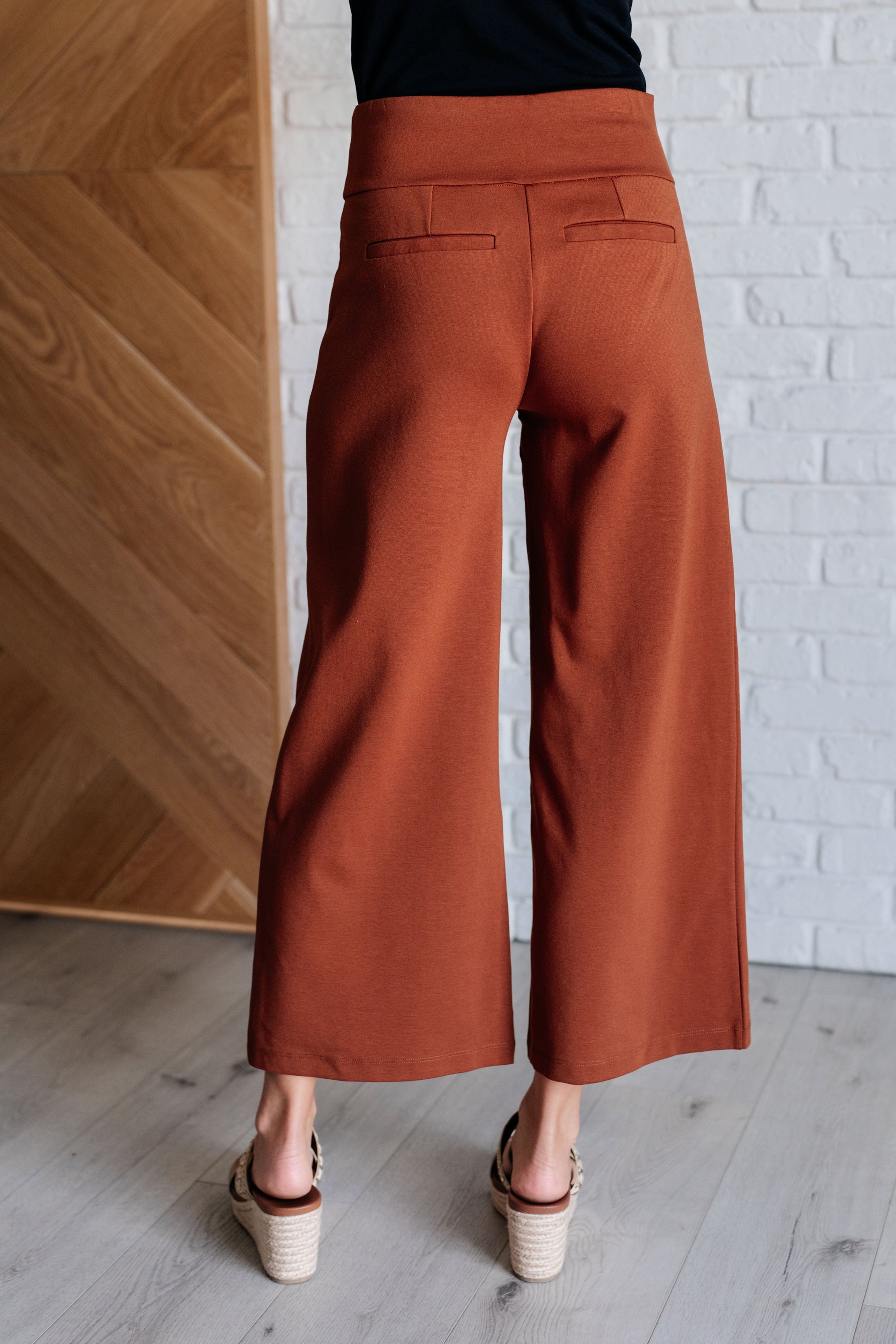 Magic Wide Leg Crop Pants in Rust, showcasing a trendy cropped design with a faux welt pocket, made from high stretch ponte knit fabric.