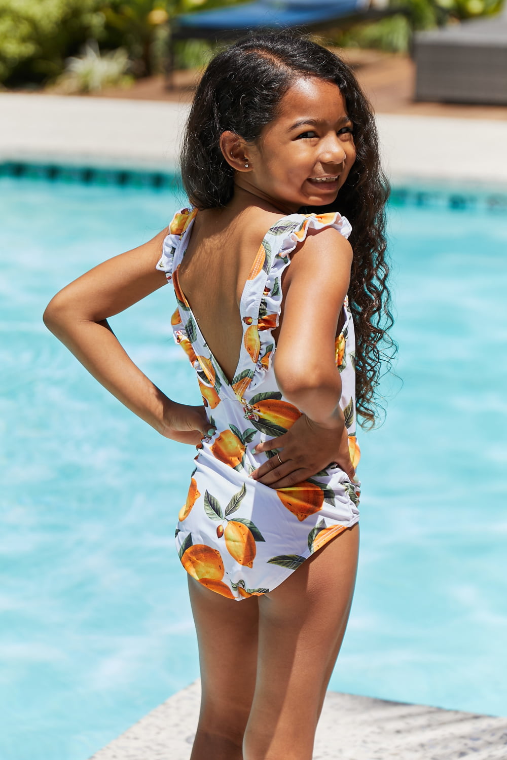 Marina West Swim Float On Ruffled One-Piece in vibrant citrus orange with stylish ruffle detailing, perfect for beach and pool activities.