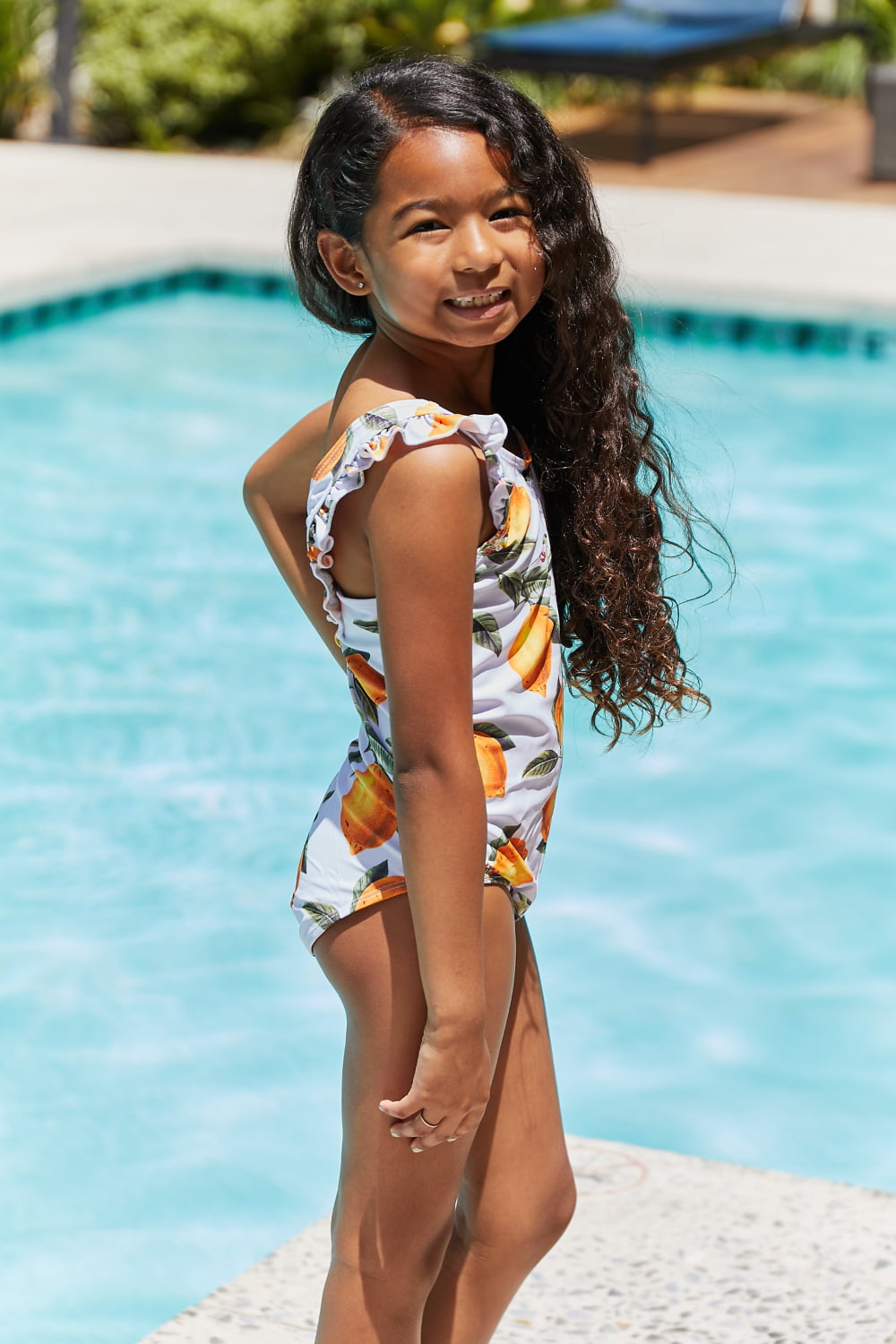 Marina West Swim Float On Ruffled One-Piece in vibrant citrus orange with stylish ruffle detailing, perfect for beach and pool activities.