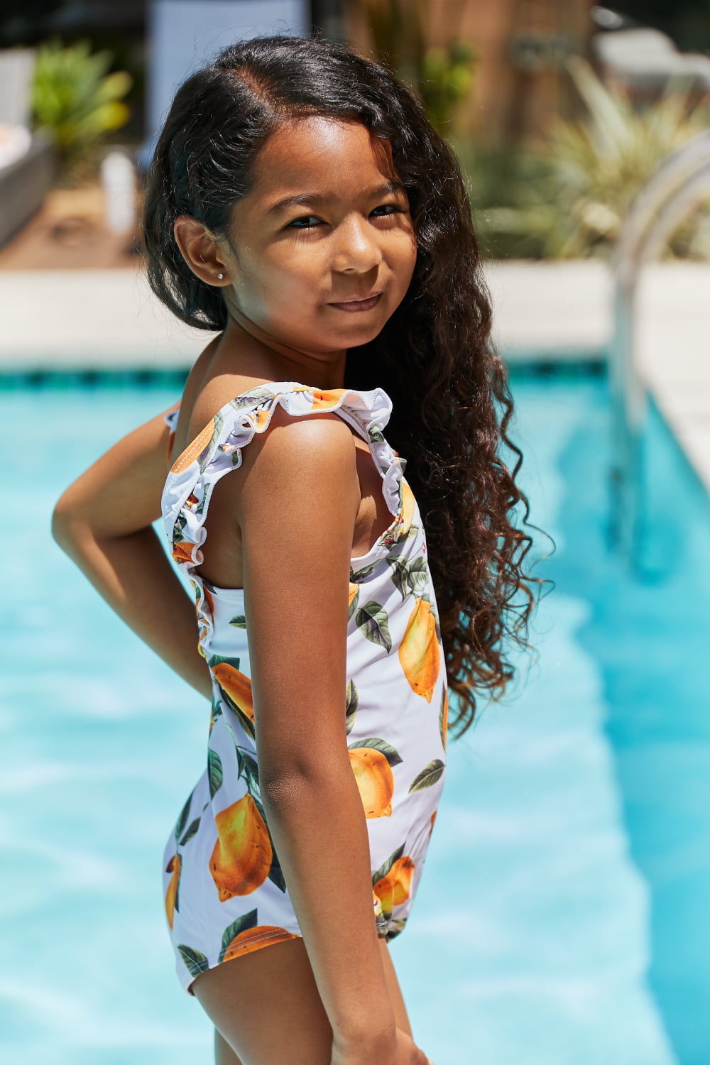 Marina West Swim Float On Ruffled One-Piece in vibrant citrus orange with stylish ruffle detailing, perfect for beach and pool activities.