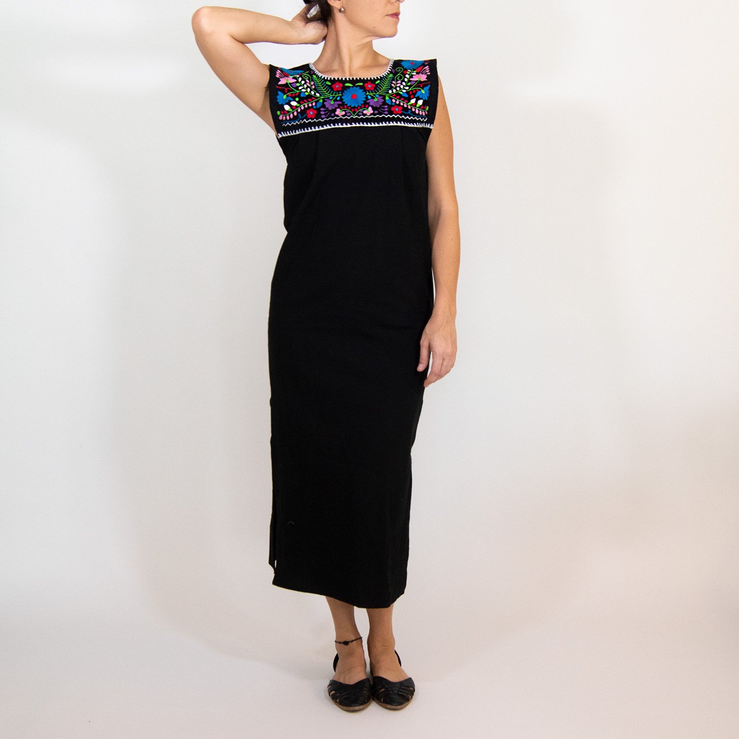 Maxi Isidra black dress featuring colorful hand-embroidered flowers, showcasing intricate craftsmanship and bohemian style.