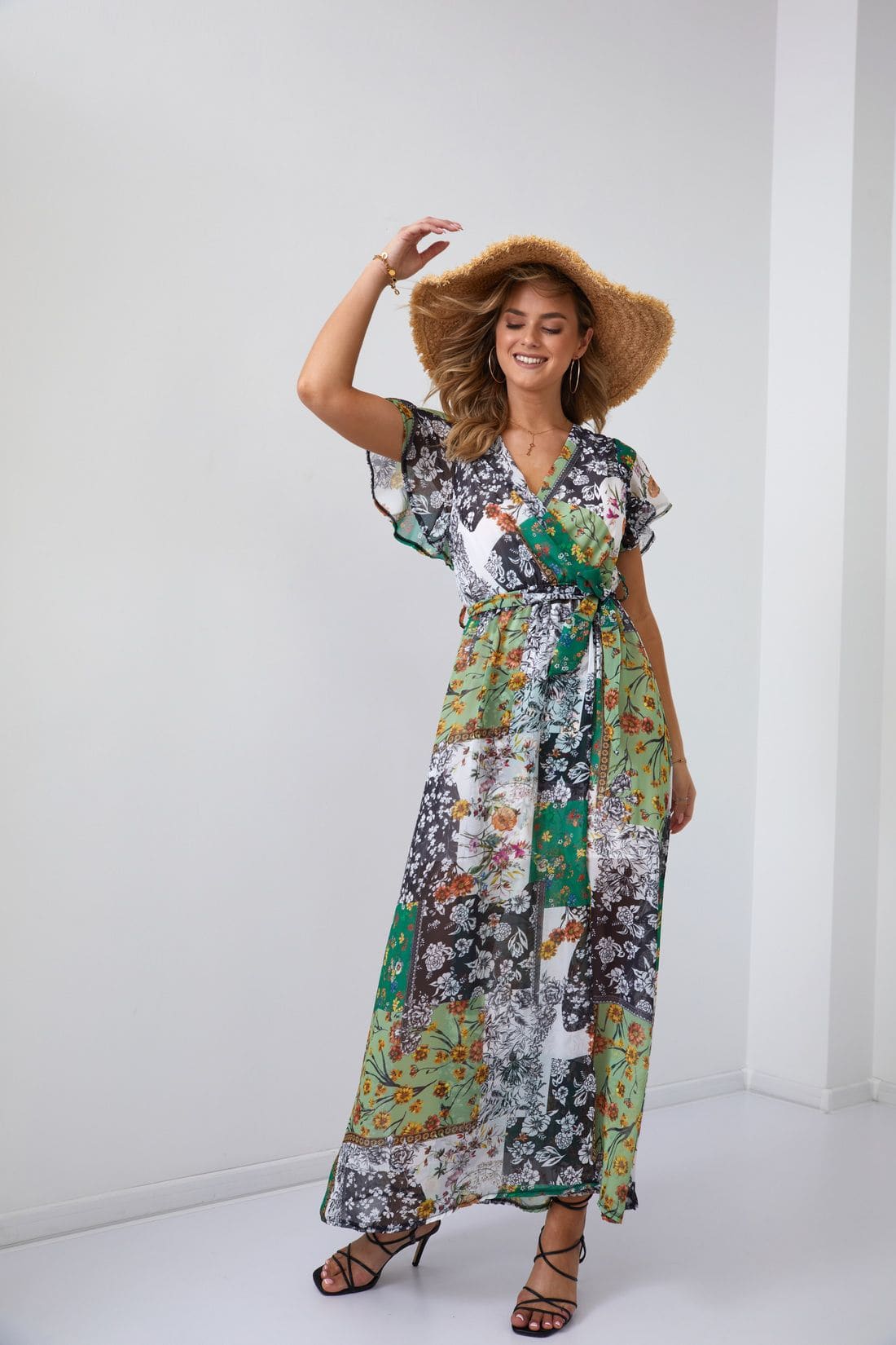 A stylish green maxi wrap dress with a floral print and a matching belt, showcasing a V-neckline and elegant design.