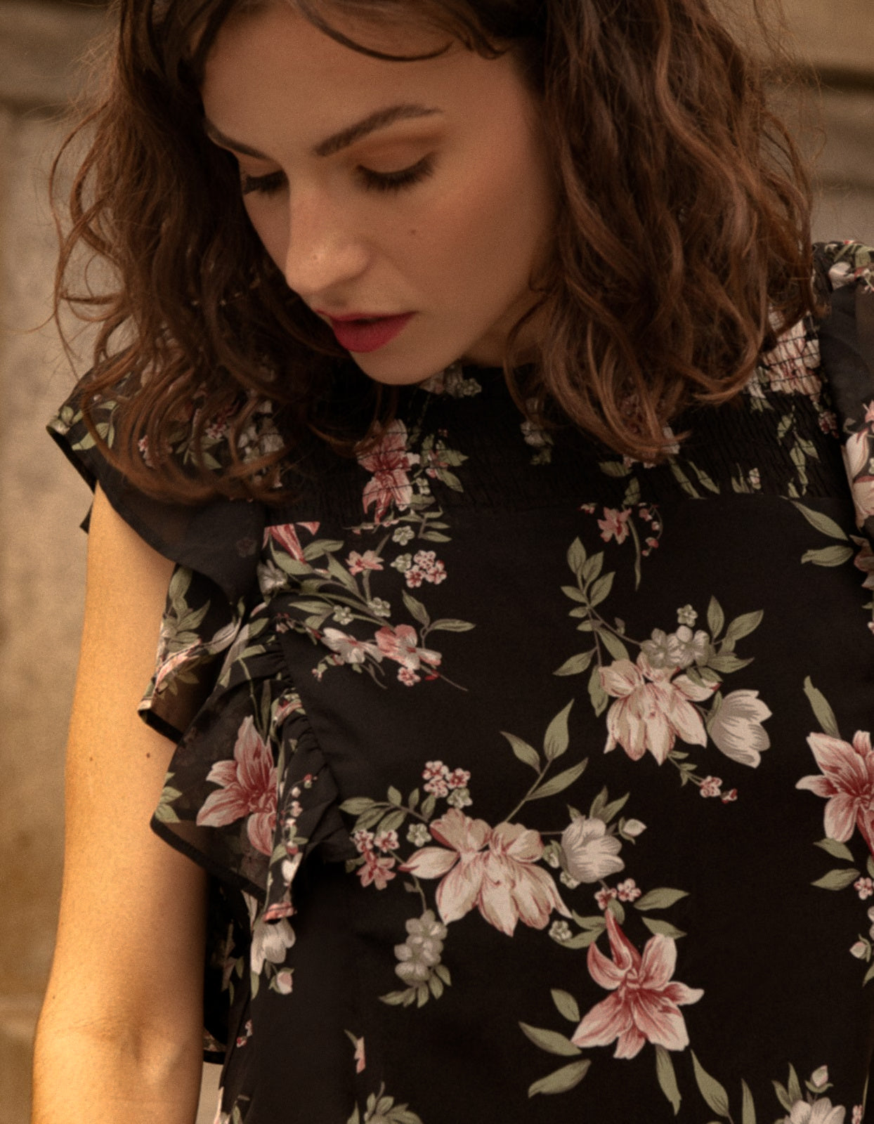 Melina Top featuring ruffled short sleeves and a vibrant floral print, perfect for casual and chic outfits.