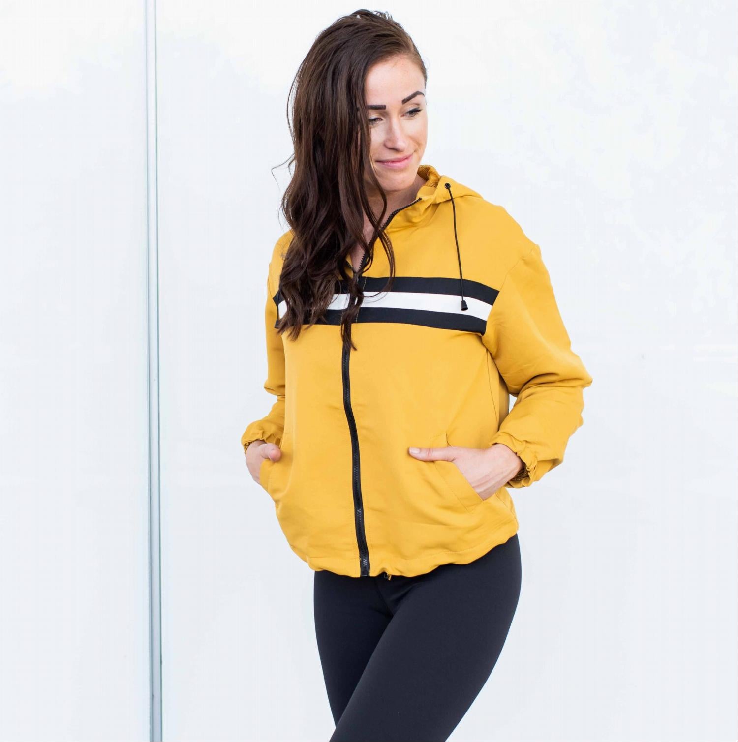 A lightweight Mesh Lined Striped Windbreaker Jacket featuring a color-blocked design, front pockets, and long sleeves, perfect for workouts.