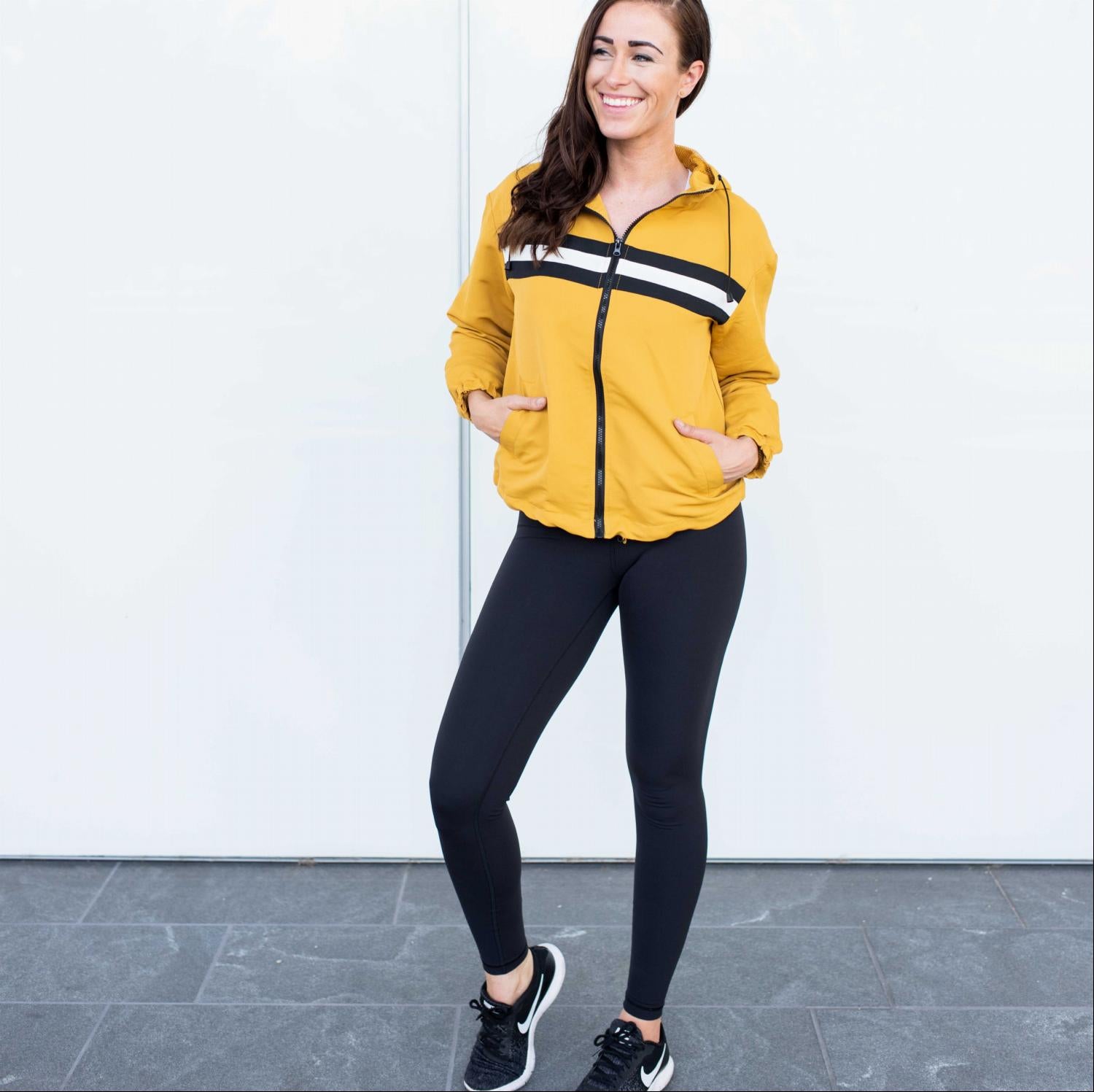 A lightweight Mesh Lined Striped Windbreaker Jacket featuring a color-blocked design, front pockets, and long sleeves, perfect for workouts.