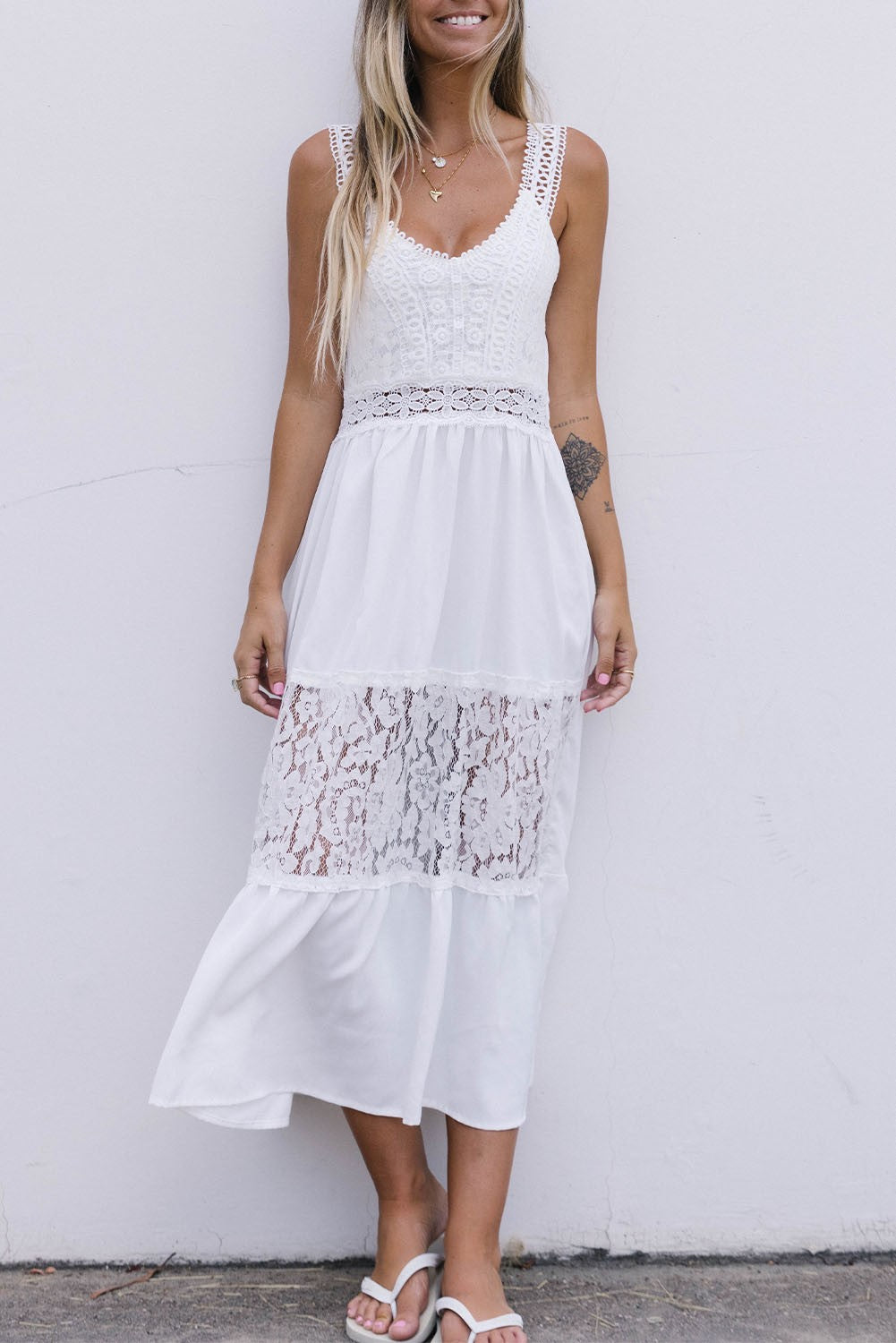 Elegant white midi dress with lace straps and plunging neckline, featuring a loose-fit skirt that falls below the knees.