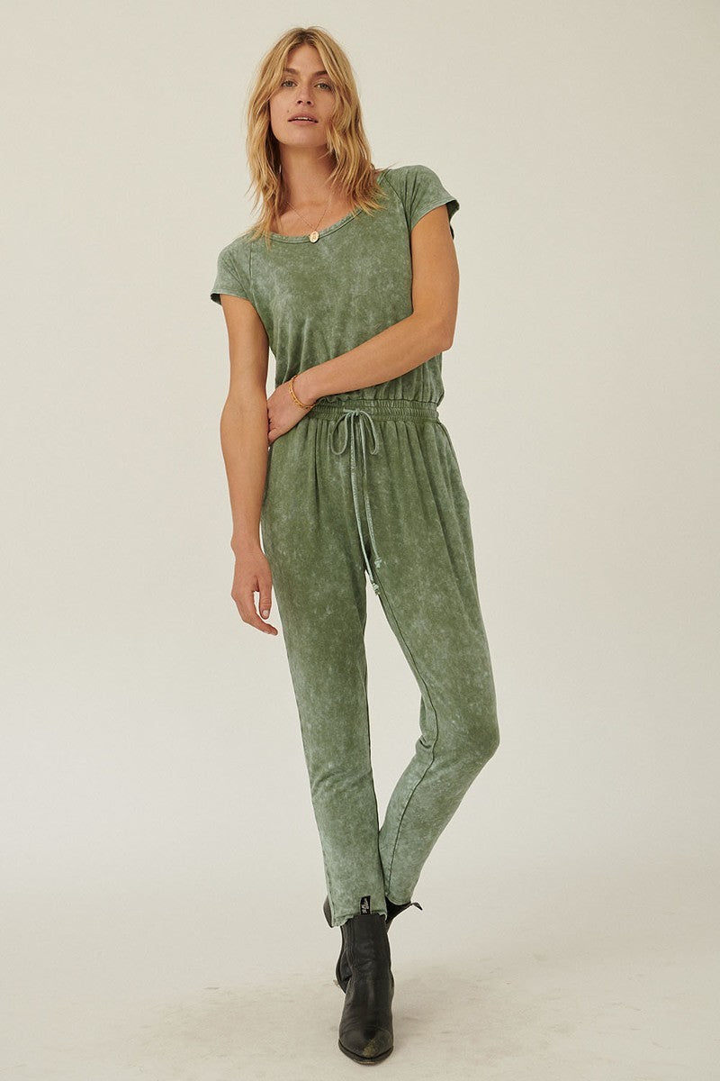 Mineral Washed Finish Knit Jumpsuit in olive color with scoop neckline and short sleeves, featuring a relaxed fit and drawstring waist.