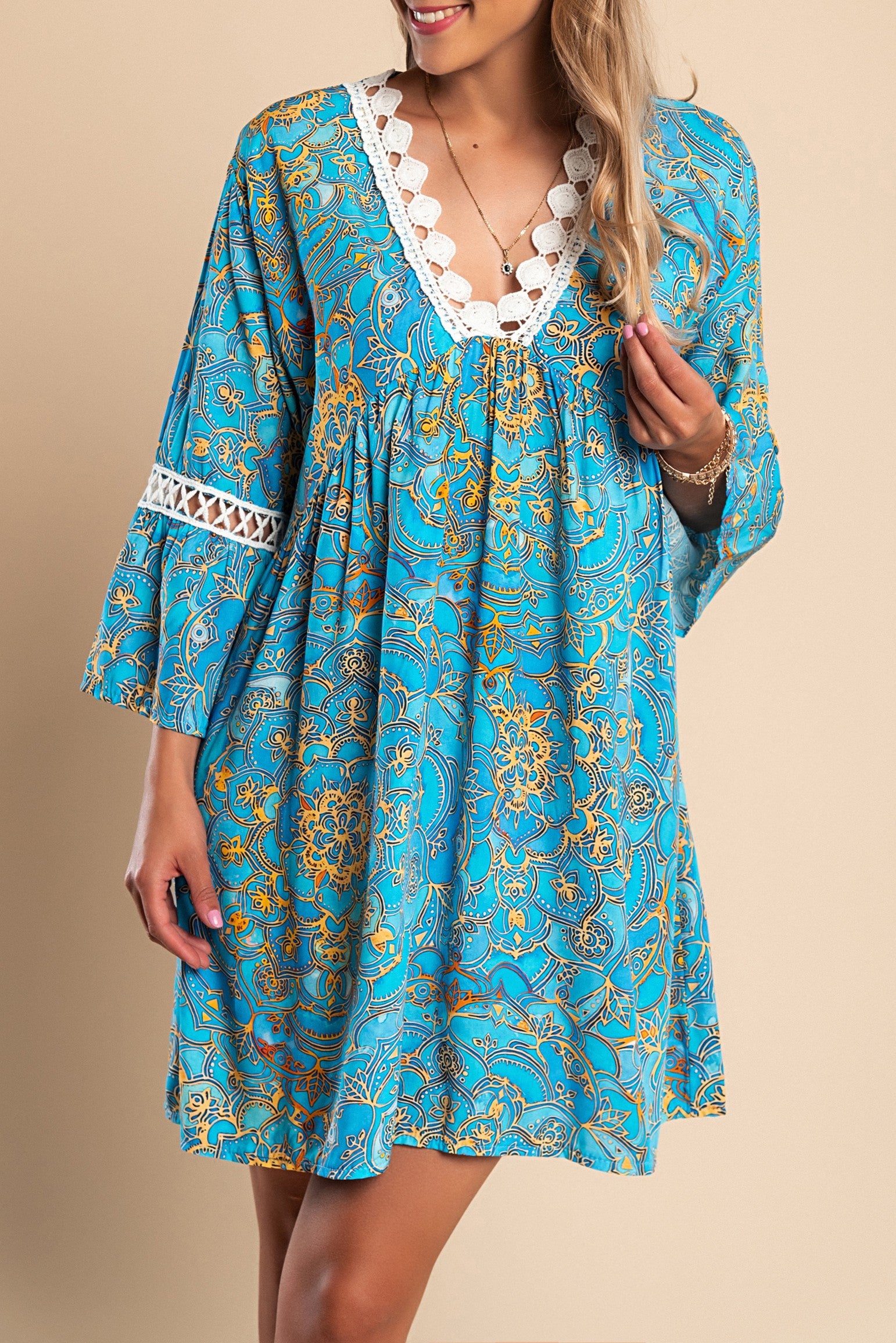 Blue mini dress with multicolor print featuring a deep V-neckline, crochet details, and ruffled 3/4 sleeves.