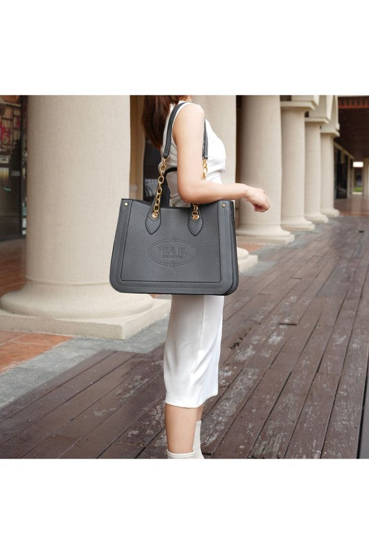 MKF Stella Tote Handbag in vegan leather with gold embellishments and embroidery, showcasing its structured design and spacious compartments.