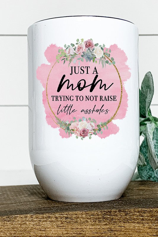 A stainless steel wine tumbler with humorous text 'Mom Trying Not to Raise Assholes', featuring a lid and straw, perfect for moms.