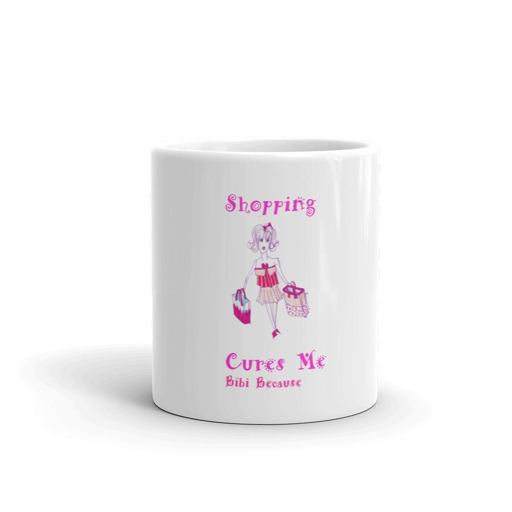 A glossy white ceramic mug with the phrase 'Because Shopping Cures Me' printed in vibrant colors, perfect for coffee or tea.