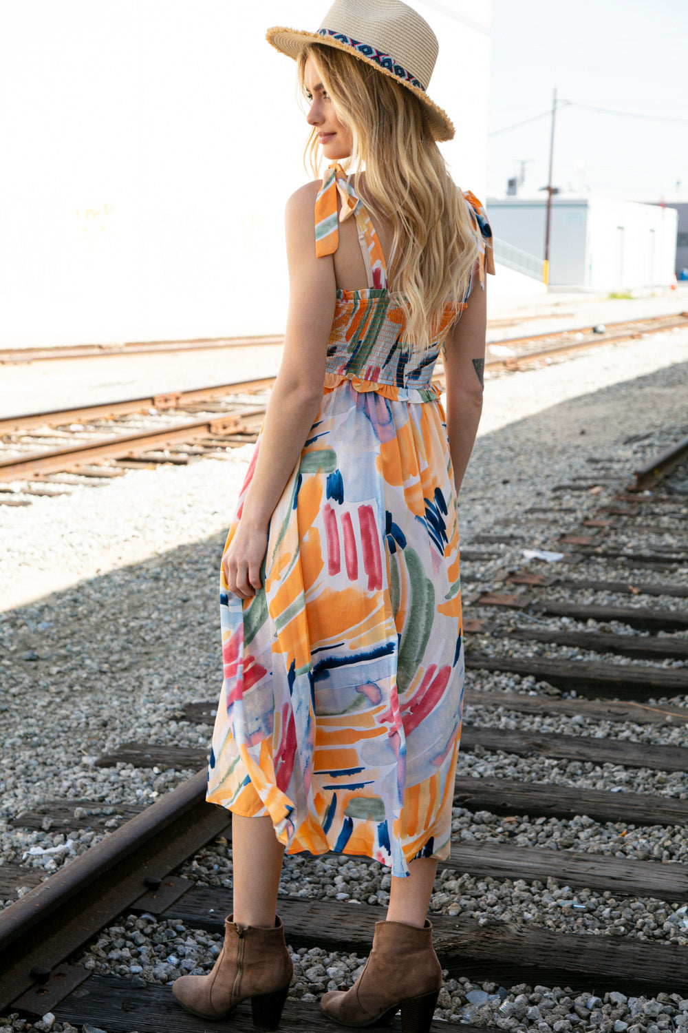 A vibrant multicolor maxi dress featuring a smocked bodice, shoulder tie straps, and ruffle details, perfect for spring occasions.