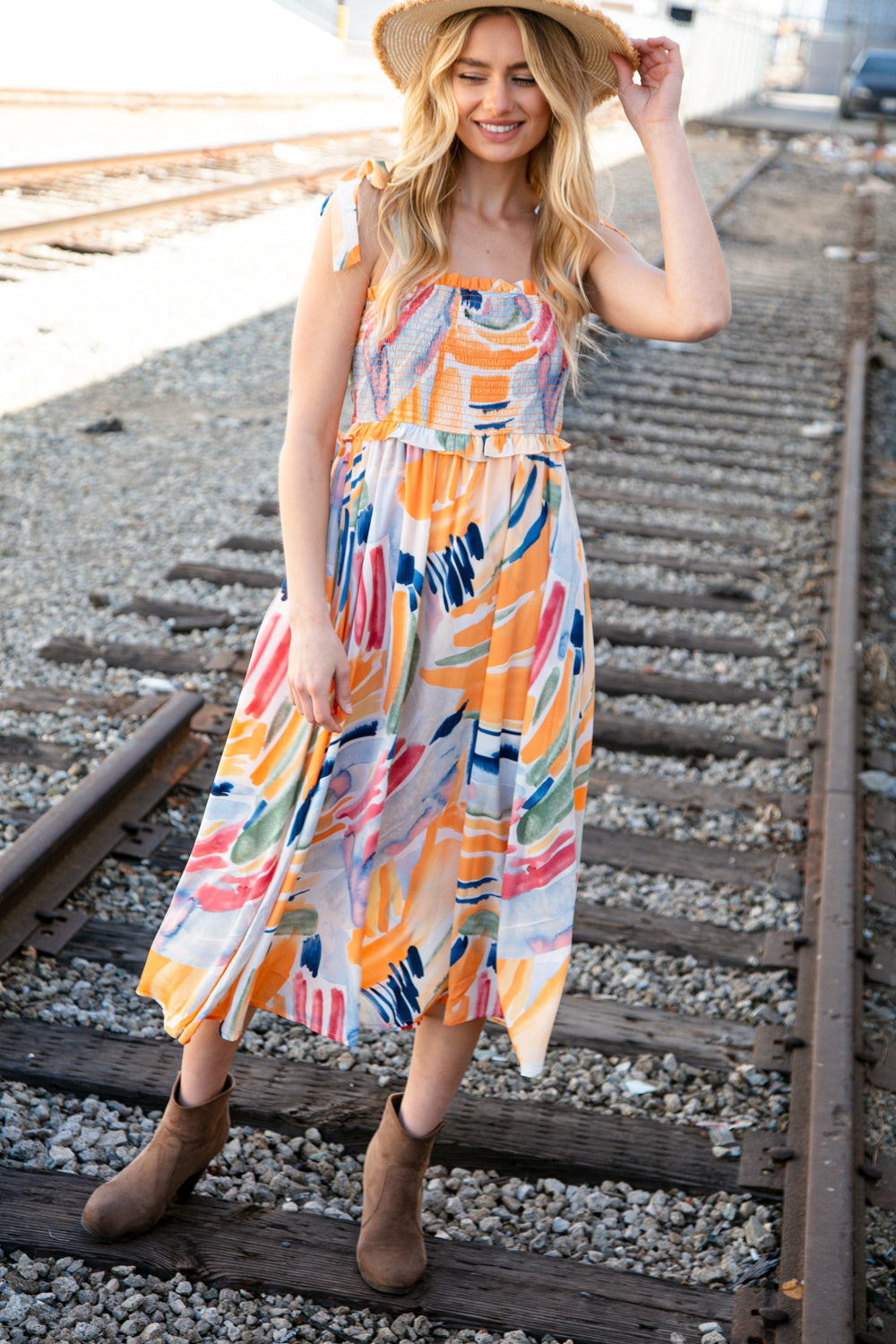 A vibrant multicolor maxi dress featuring a smocked bodice, shoulder tie straps, and ruffle details, perfect for spring occasions.