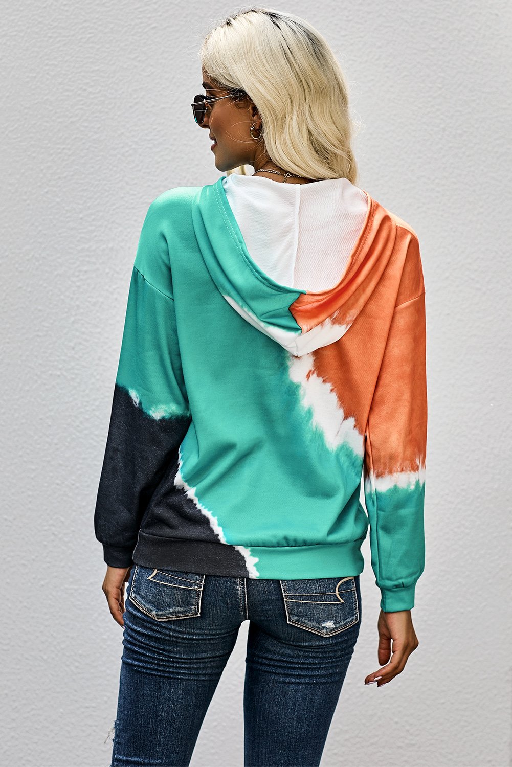 A vibrant multicolor tie-dye print hoodie displayed on a mannequin, showcasing its stylish design and comfortable fabric.