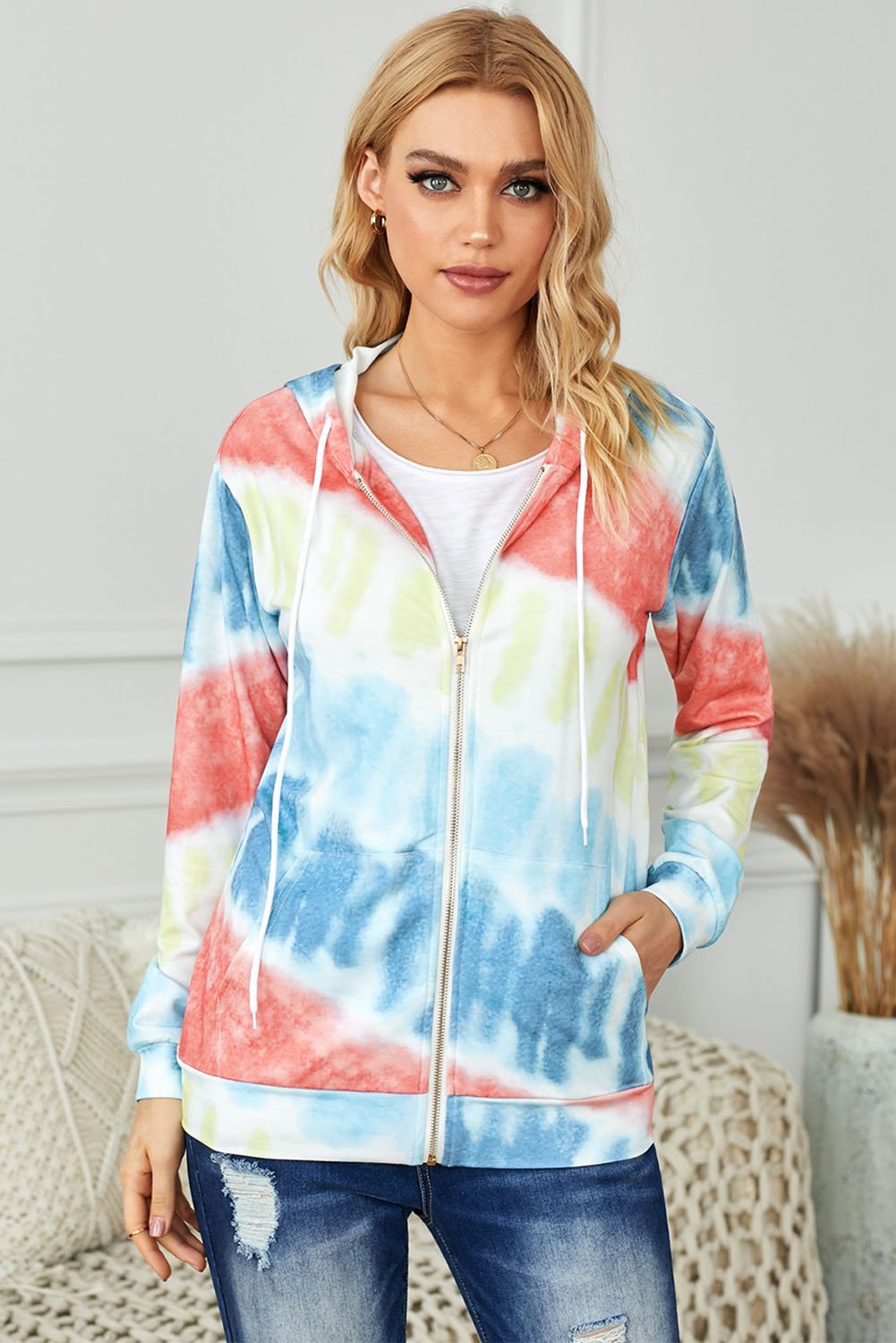 Multicolor tie-dyed hooded jacket with zipper pockets, showcasing vibrant colors and stylish design.