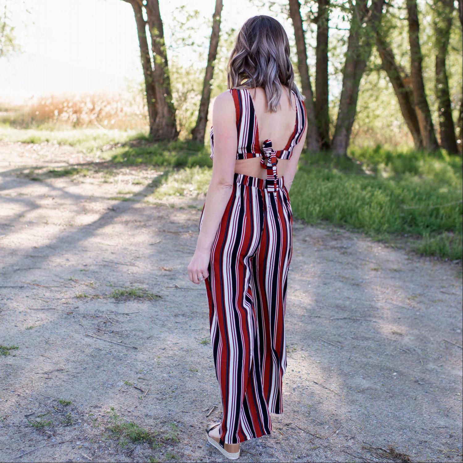 A stylish multicolored jumpsuit with vertical stripes, wide legs, and a cutout back design, perfect for various occasions.