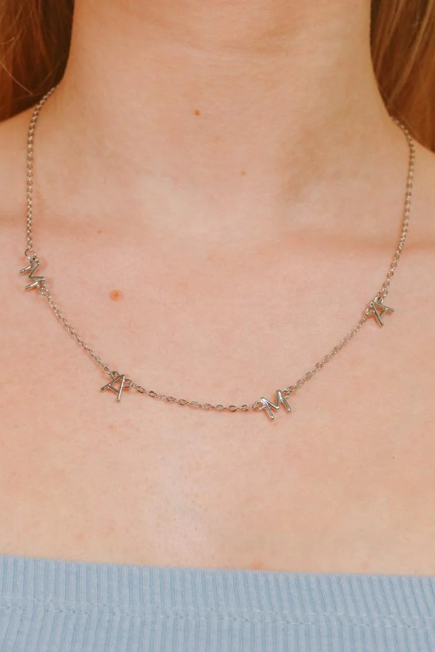 Elegant silver necklace featuring letter-shaped pendant with 'MOM' inscription, crafted from 100% brass.
