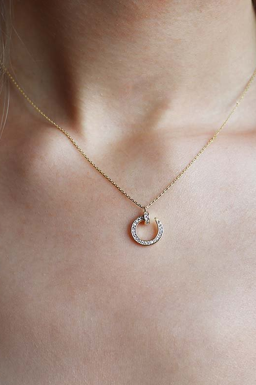 Elegant gold necklace with rhinestone pendant and metal carabiner closure, showcasing a stylish design.