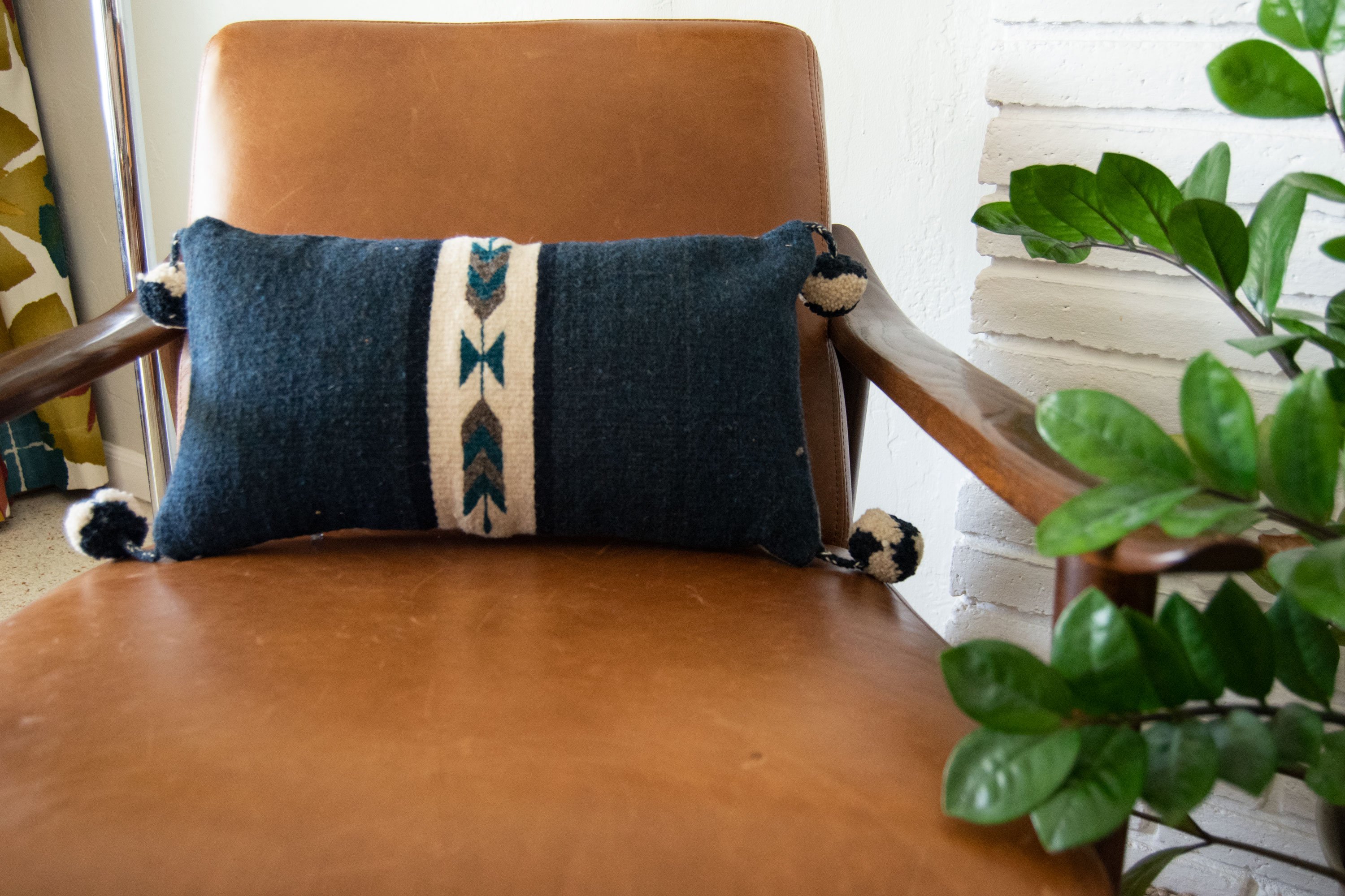 Neza Navajo Arrows hand-woven wool pillow cover featuring geometric designs and pompons, perfect for home decor.
