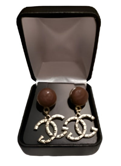 A pair of elegant gold and brown earrings, showcasing a high-quality replica design, perfect for any occasion.