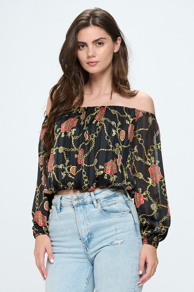 Off-shoulder long-sleeve crop top in red chiffon with gold chain print, featuring elastic wrist detail.