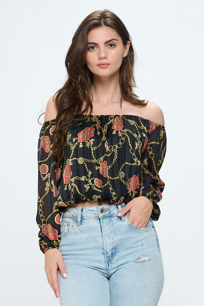 Off-shoulder long-sleeve crop top in red chiffon with gold chain print, featuring elastic wrist detail.