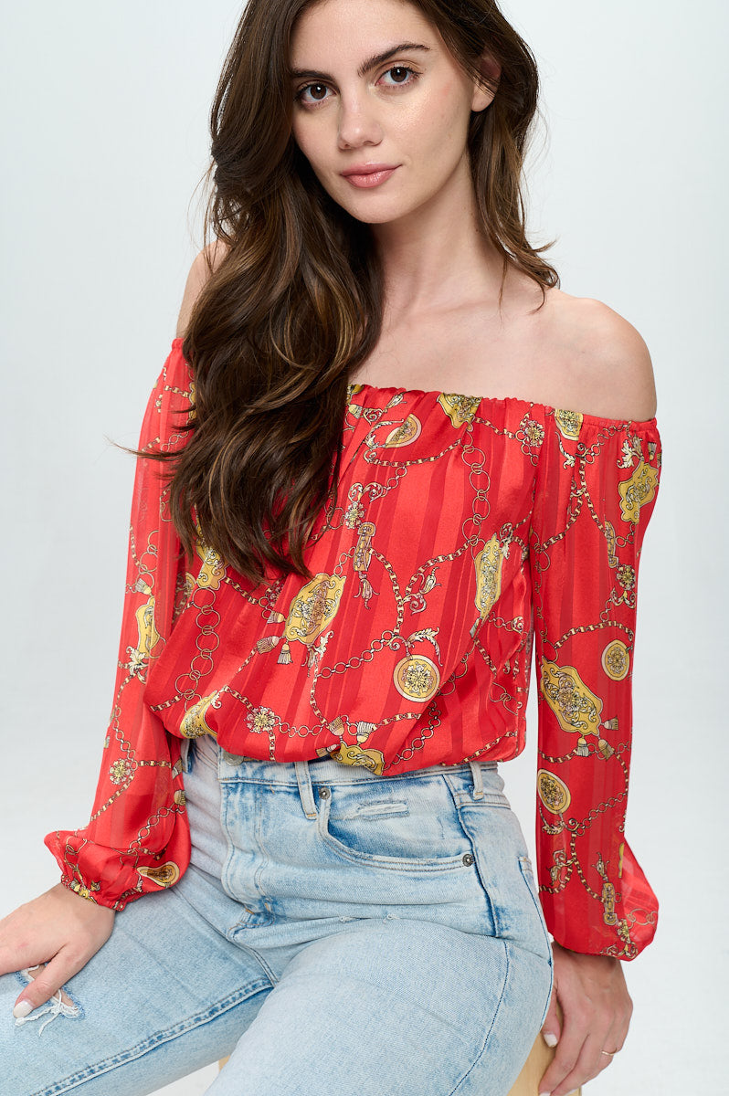 Off-shoulder long-sleeve crop top in red chiffon with gold chain print, featuring elastic wrist detail.
