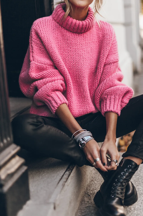Ohlapen roza pulover z visokim ovratnikom in dolgimi rokavi, idealen za udobno nošenje.