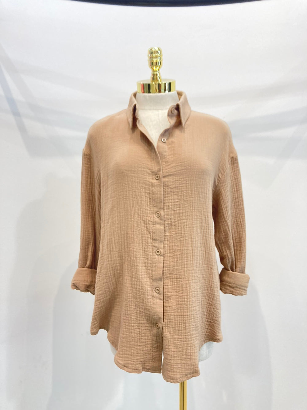 A stylish oversized button-up shirt made from soft solid gauze, featuring a button front and a slit back design for added breathability.