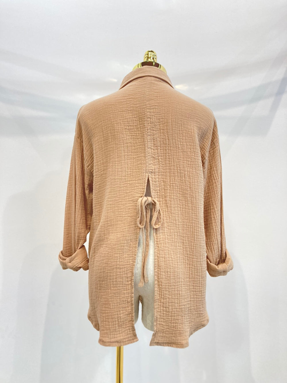 A stylish oversized button-up shirt made from soft solid gauze, featuring a button front and a slit back design for added breathability.